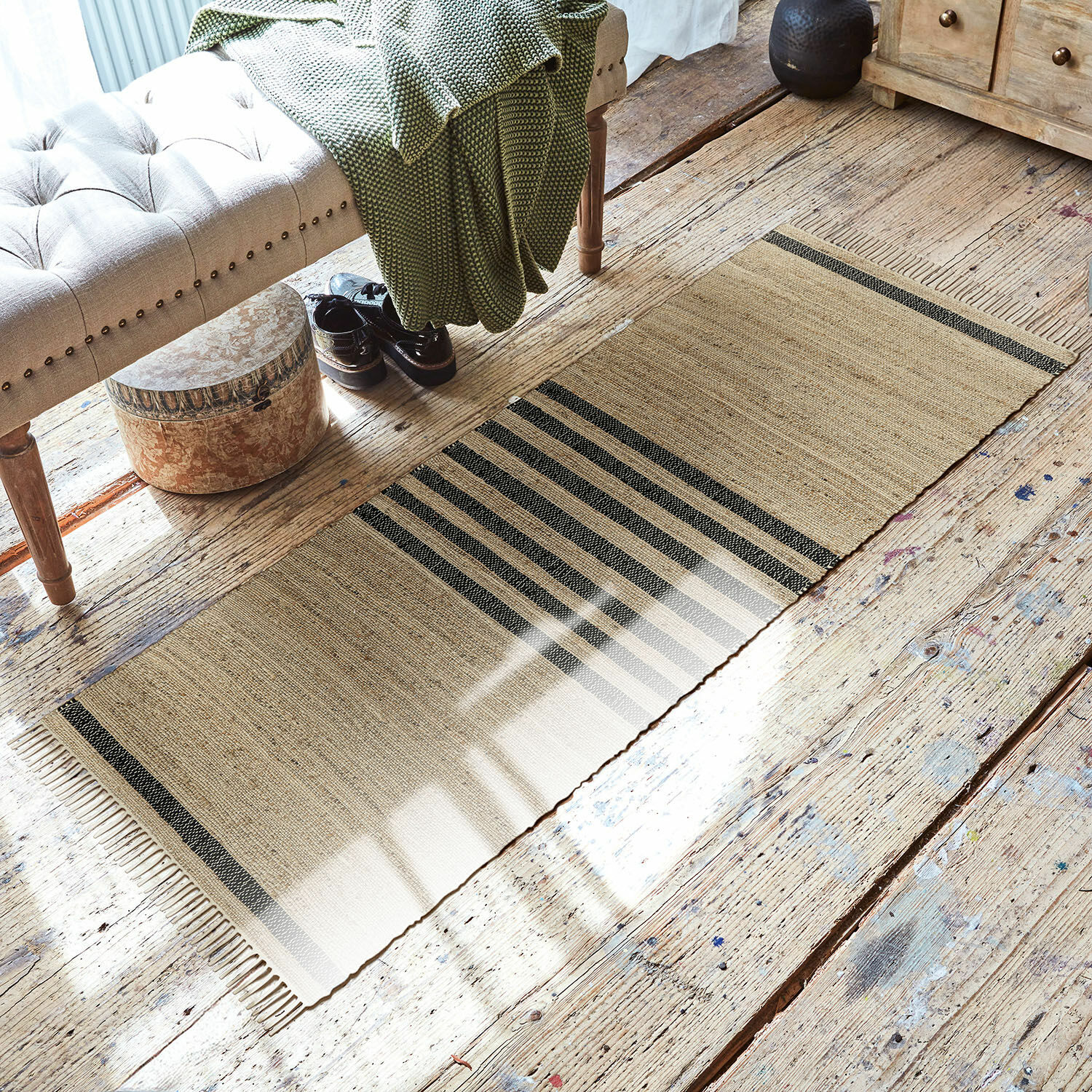 Tapis long Orgeval Tapis beige à rayures noires en matériau naturel sur un sol en bois dans un salon lumineux