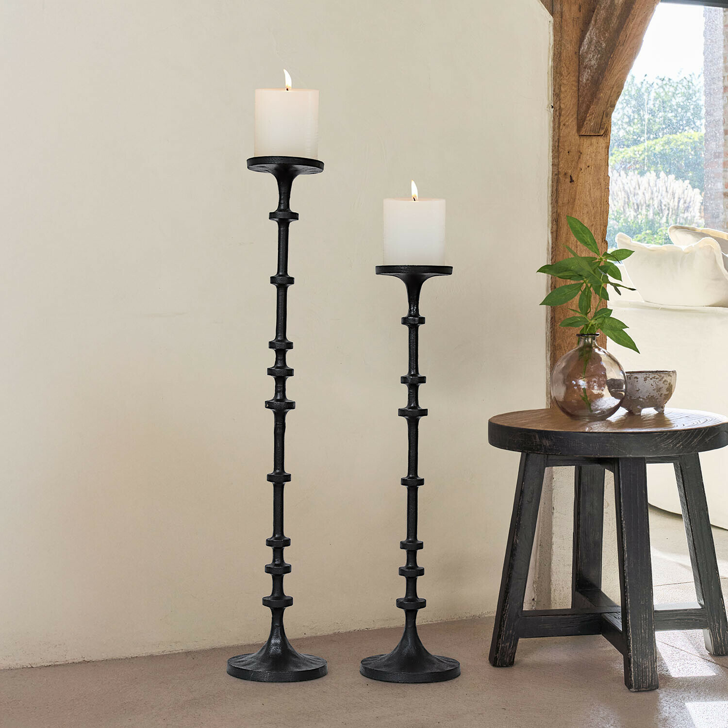 Lot de 2 bougeoirs Reville Ensemble de deux bougeoirs en métal noir avec bougies blanches, décoration intérieure lumineuse et naturelle