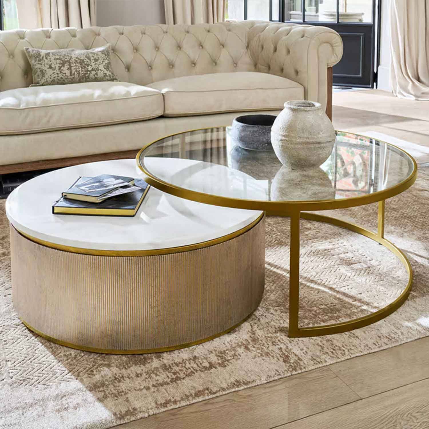 Ensemble de deux tables basses avec plateau en marbre blanc et verre, cadre doré dans un salon élégant