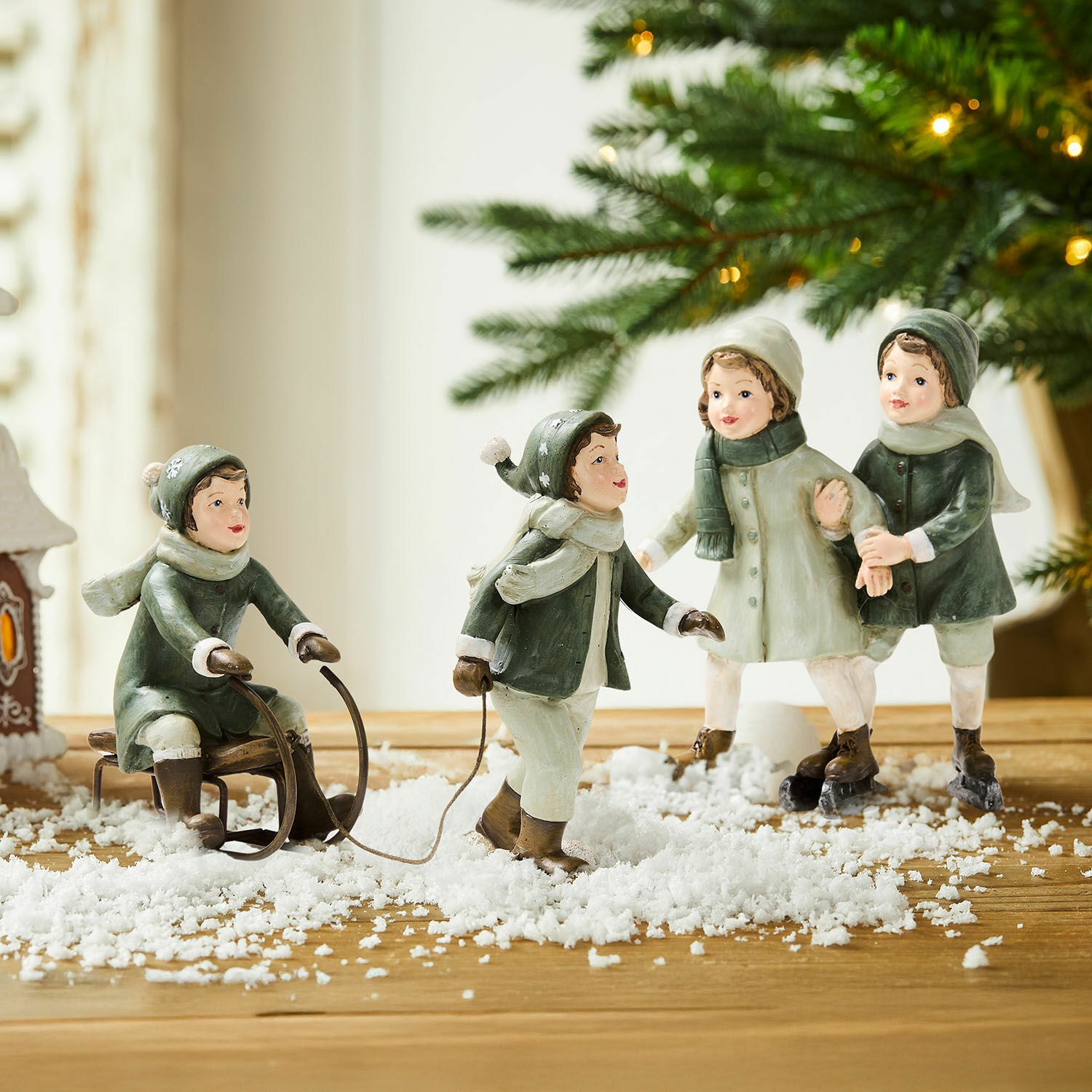 Beeldje set van 2 Andros Beeldjes van kinderen die in de sneeuw spelen met slee en schaatsen, winterdecoratie op houten tafel