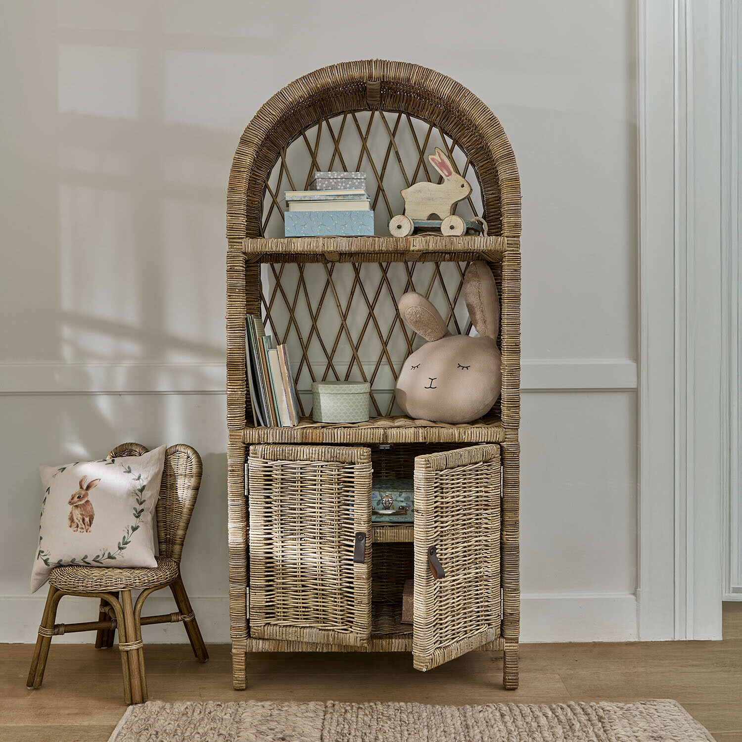 Armoire Brierdale Étagère en osier naturel avec étagères arrondies et placard, décorations enfantines et coussin lapin beige