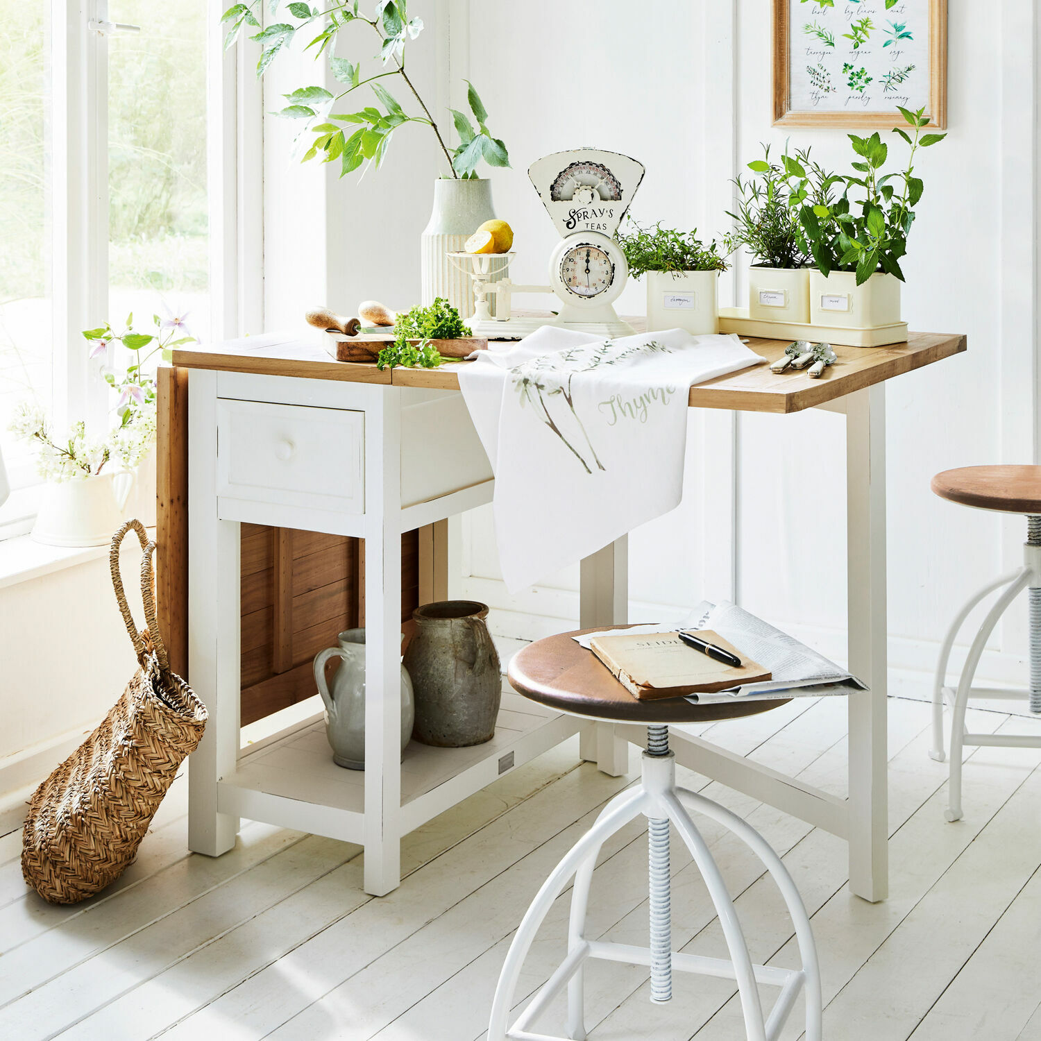 Tafel Dale Witte houten keukentafel met licht houten blad en groene planten in potten