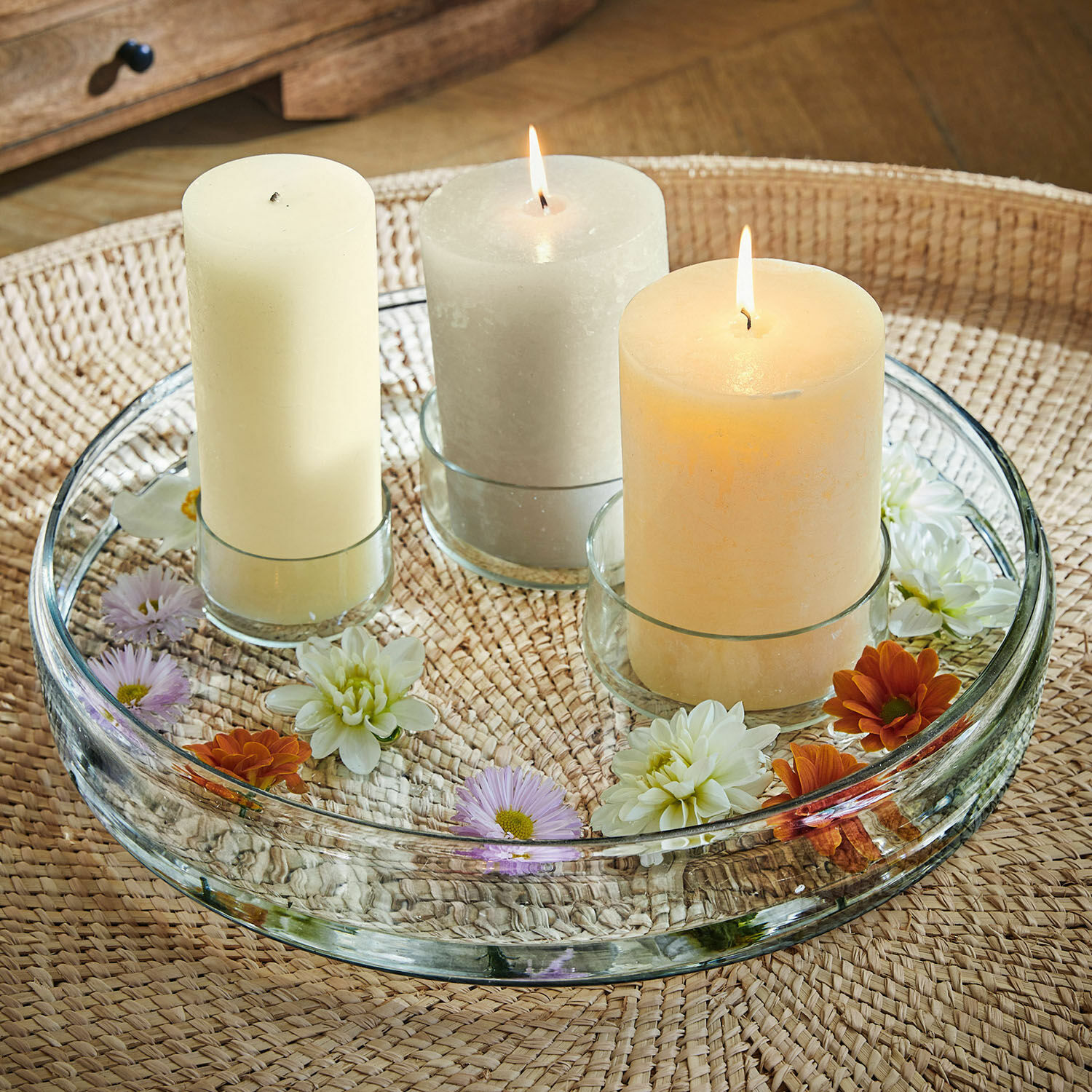 Kaarsenplateau Marton Glazen dienblad met drie kaarsen in pasteltinten en bloemen op gevlochten tafel