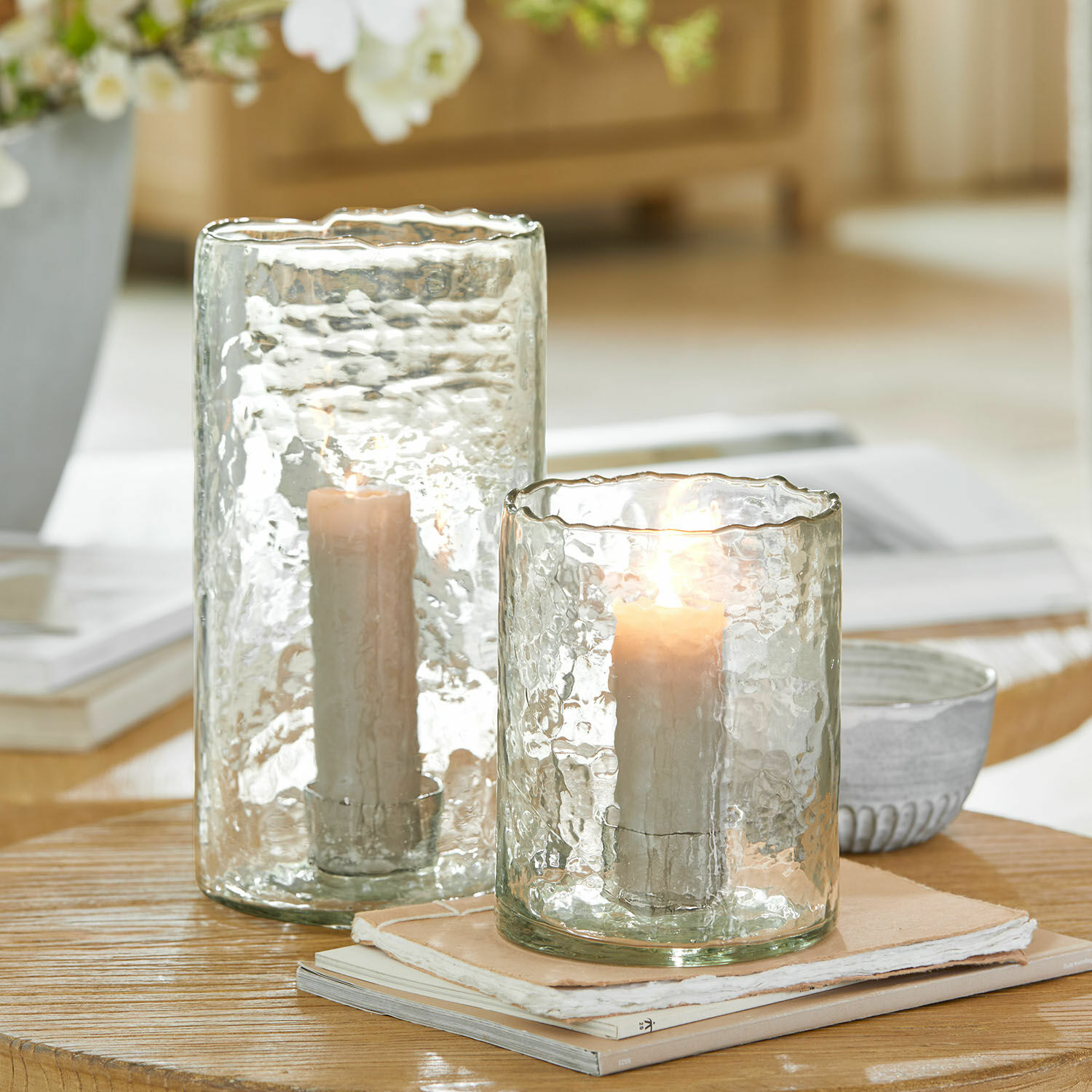 Windlicht set van 2 Querlay Twee windlichten van gestructureerd transparant glas met witte kaarsen op houten tafel