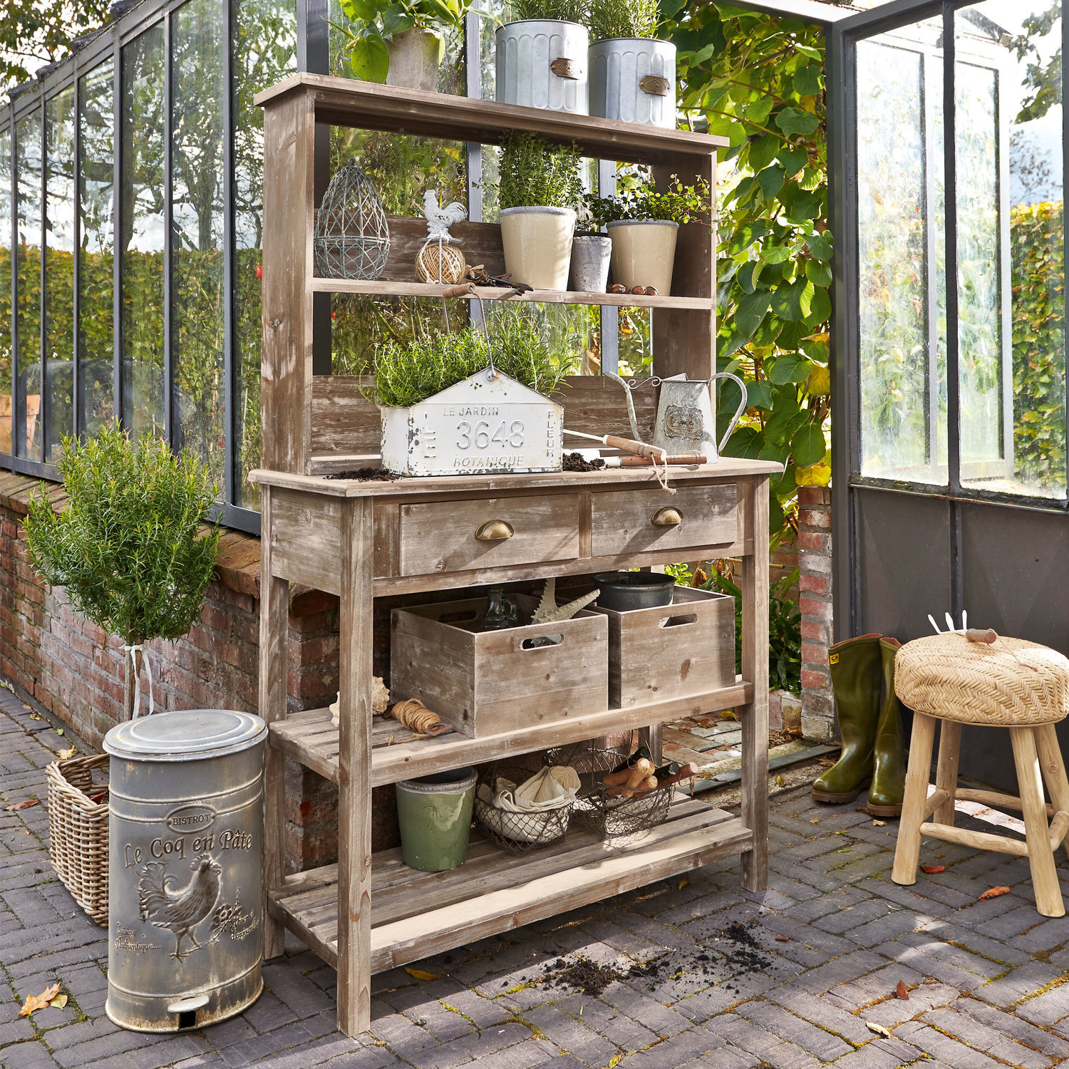 Meuble de jardinage Landover Table de jardin en bois avec étagères, pots de fleurs, outils de jardinage et plantes vertes dans une serre