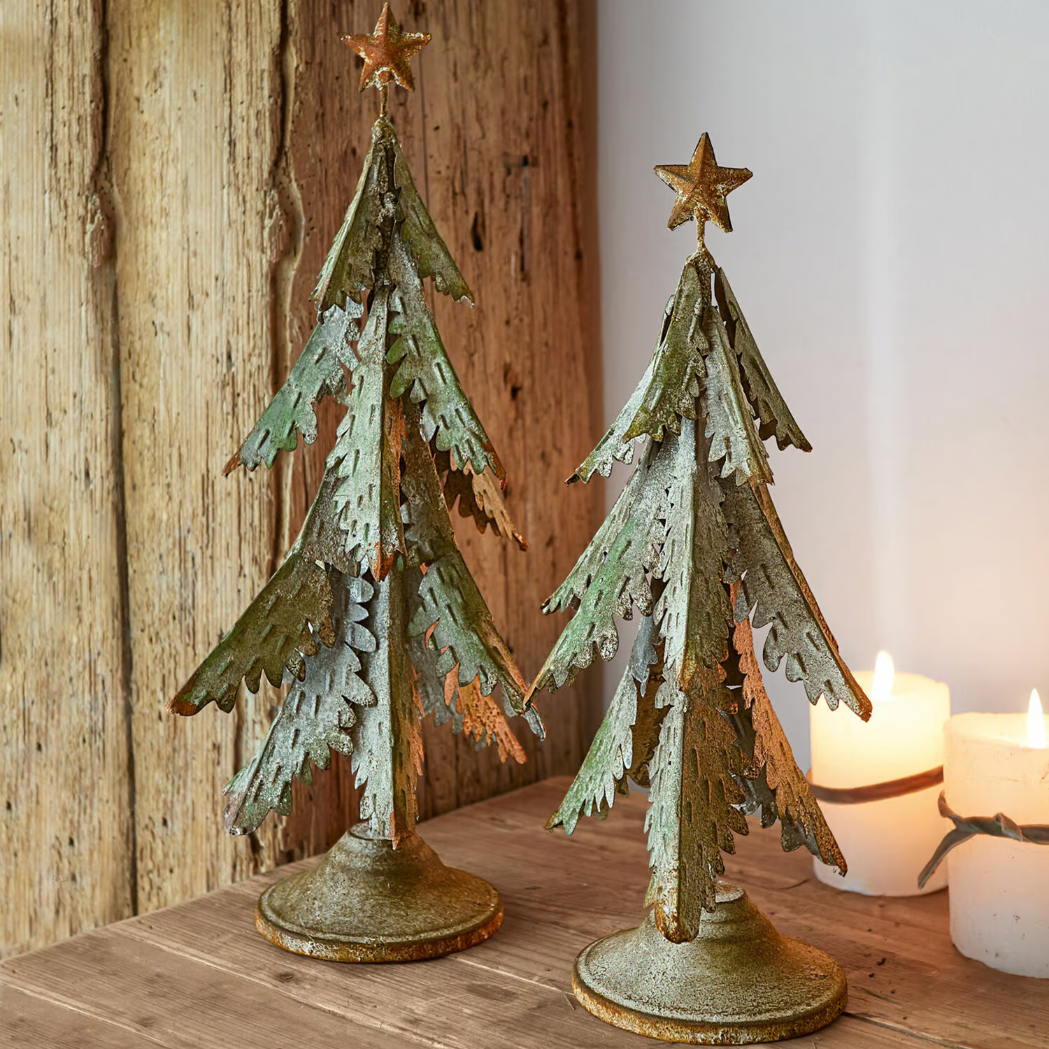 Twee groene metalen kerstbomen met gouden sterren, rustieke kersttafeldecoratie