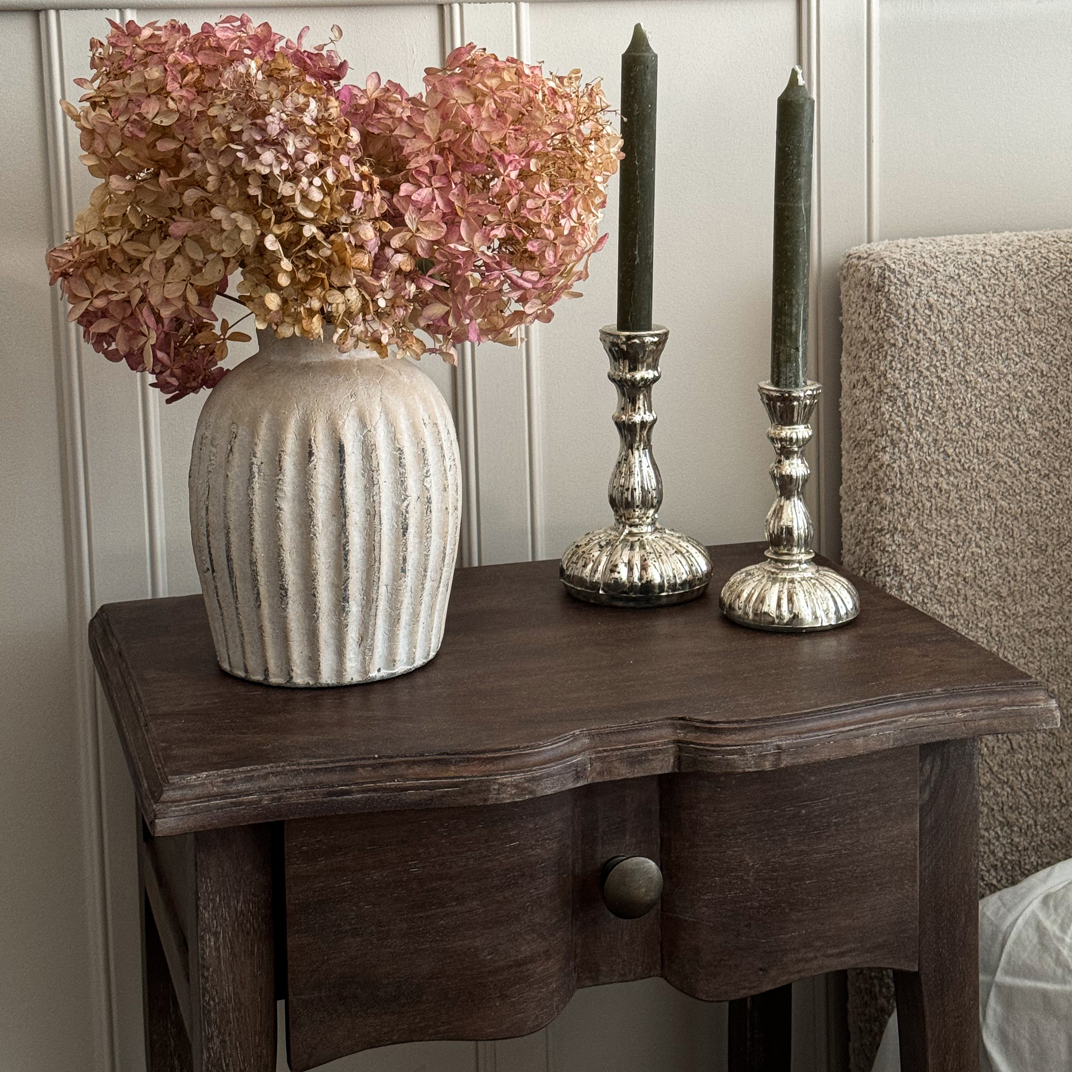 Vase en céramique beige avec fleurs séchées roses sur une table en bois pour décoration intérieure