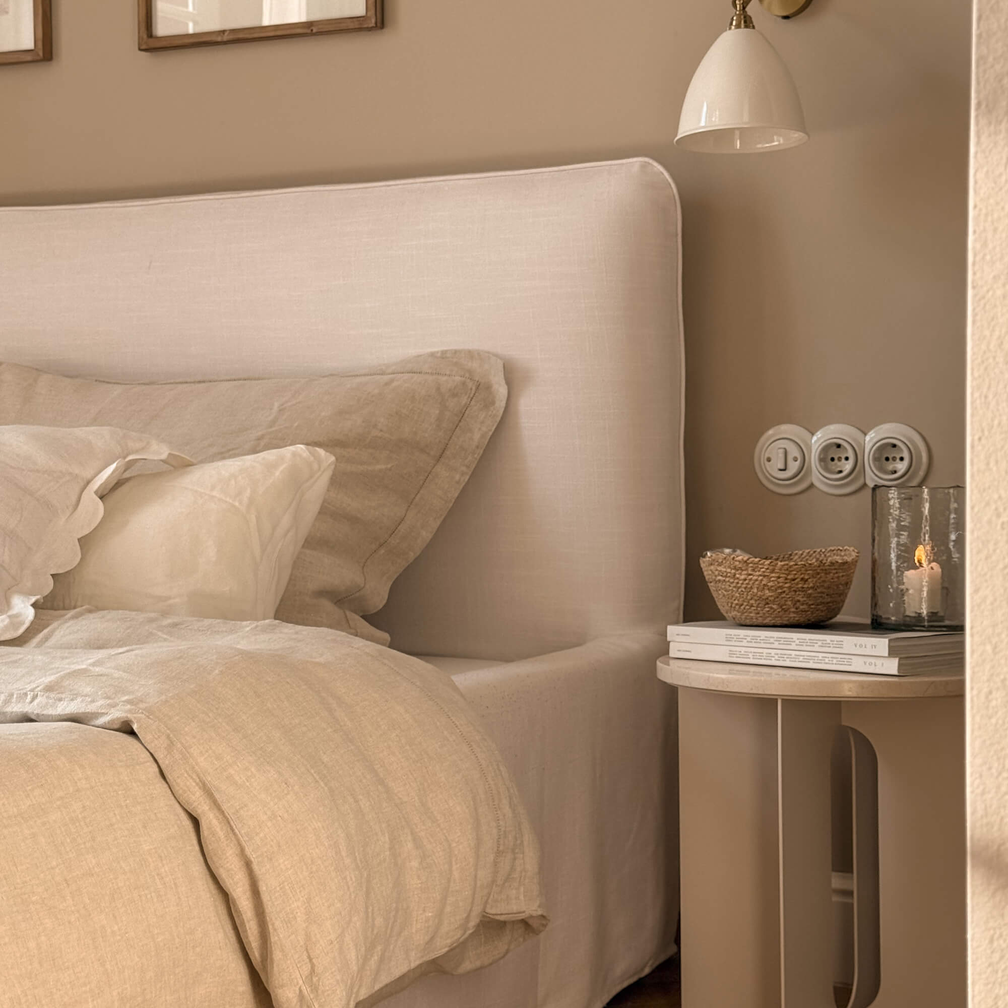 Gezellige slaapkamer met beige gestoffeerd bed en natuurlijk linnen beddengoed