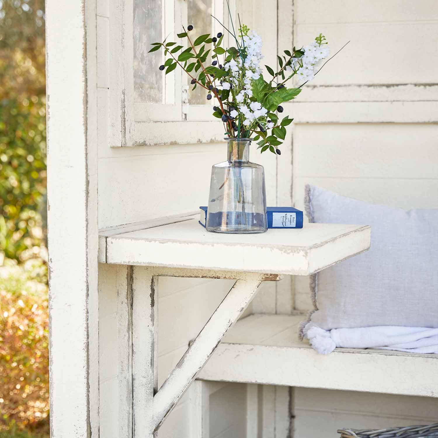 Table pliante en bois blanc avec vase transparent et fleurs, décoration extérieure élégante