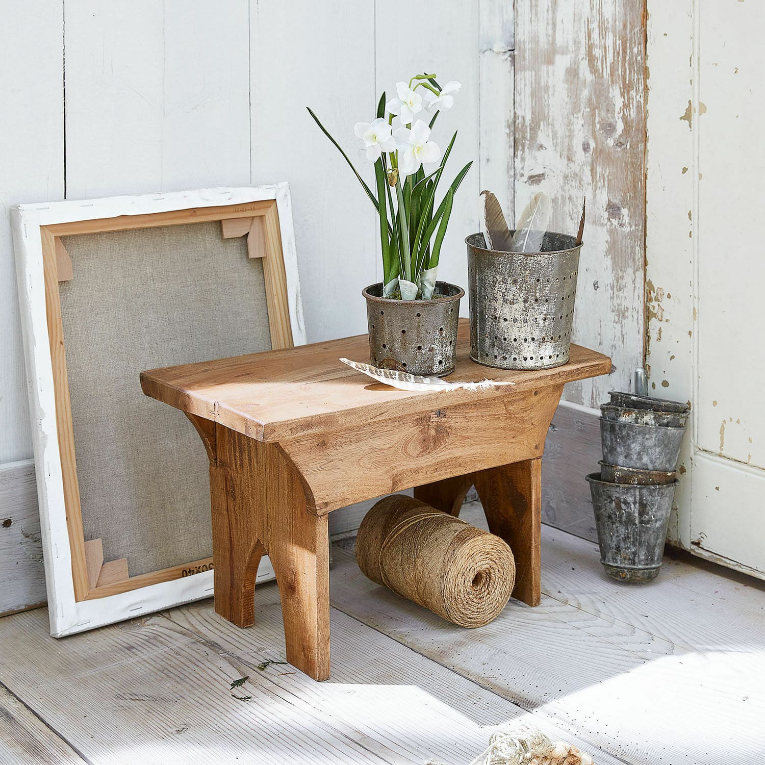Krukje Hoboken Kleine houten kruk met metalen potten en witte bloemen op lichte houten vloer
