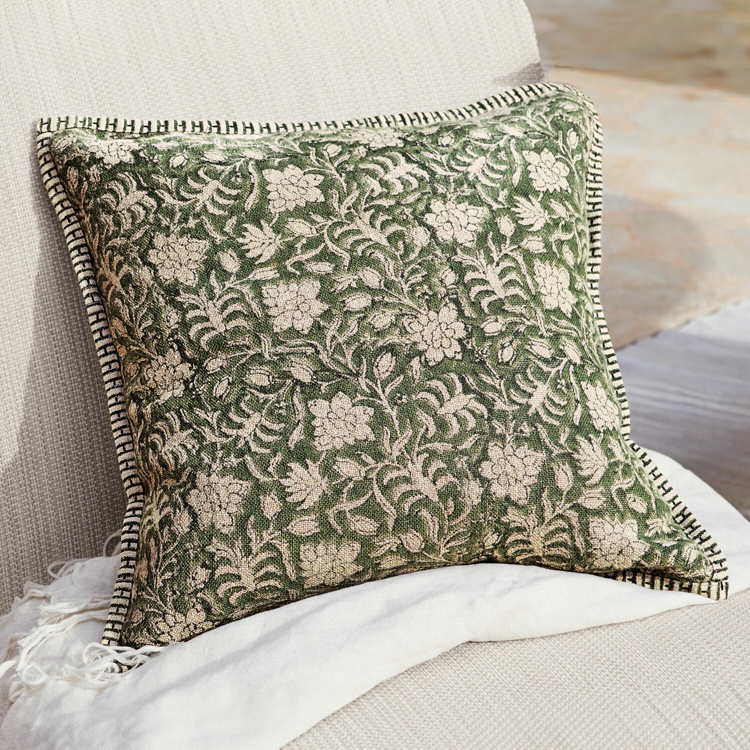 Housse de coussin Petitmagny Coussin décoratif vert en coton avec motif floral et bordure noire et blanche sur canapé clair