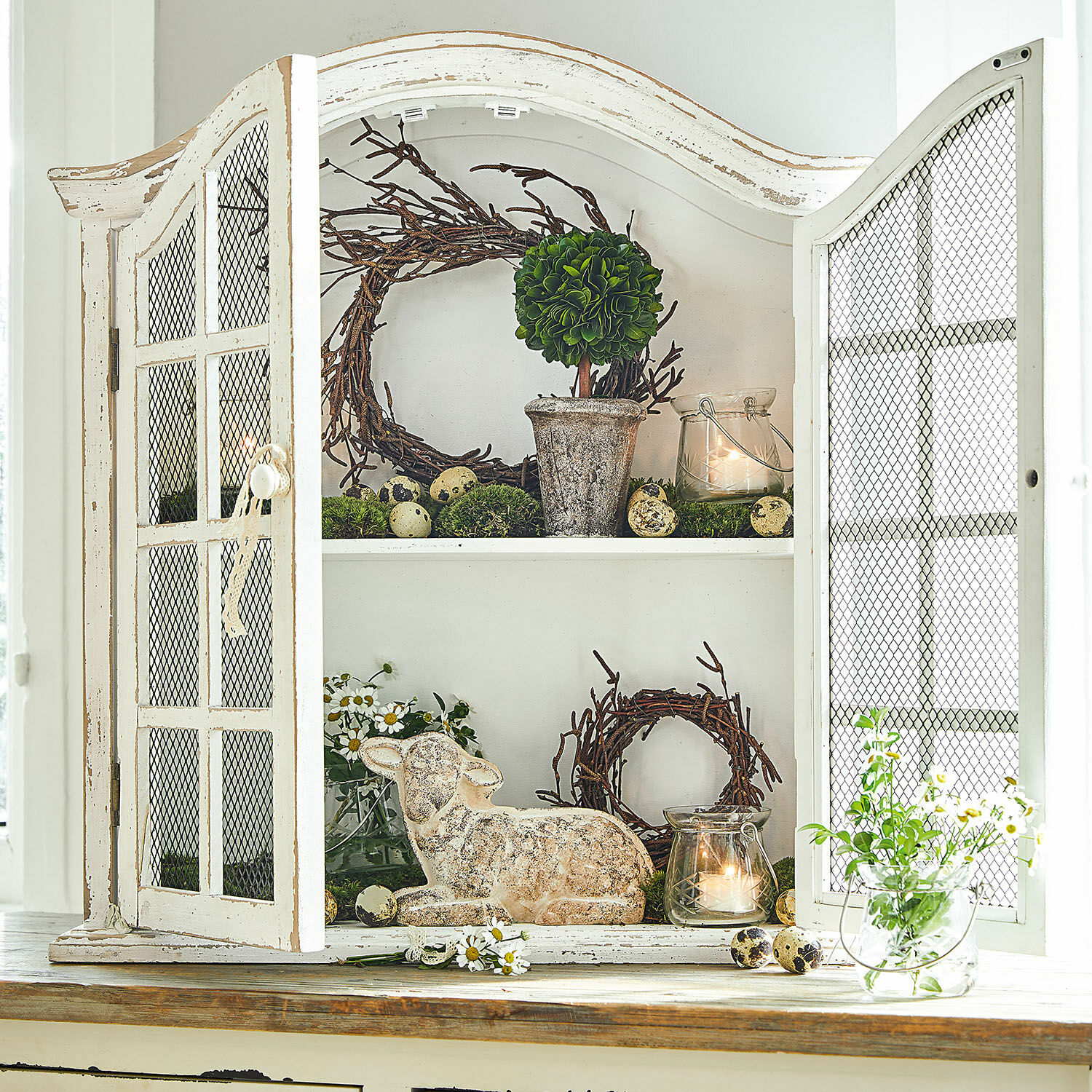 Wandkast Monthelie Witte houten kast met gaasdeuren en rustieke decoratie op de planken