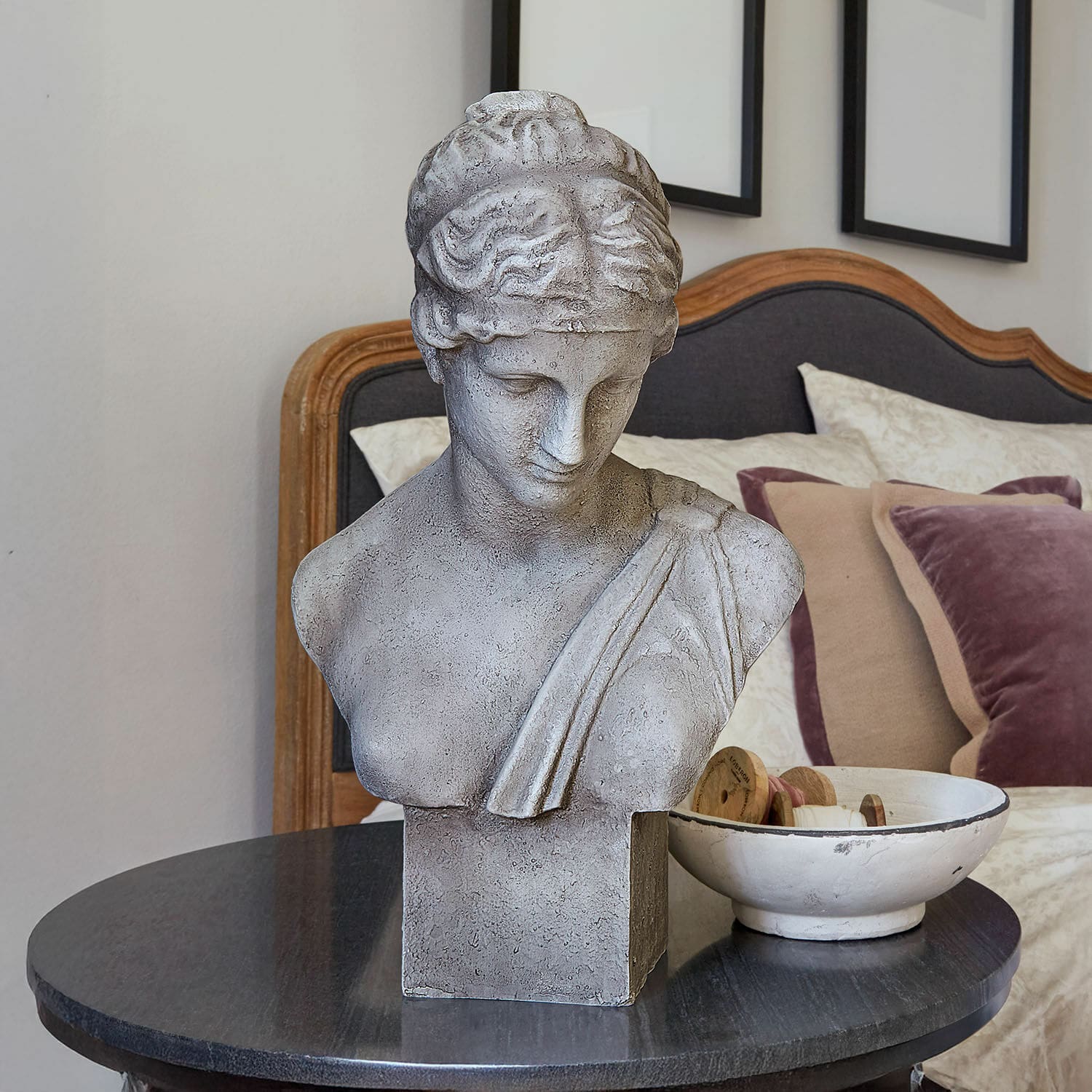 Buste Castolio Grijs stenen buste op zwarte tafel in elegante kamer met sierkussens