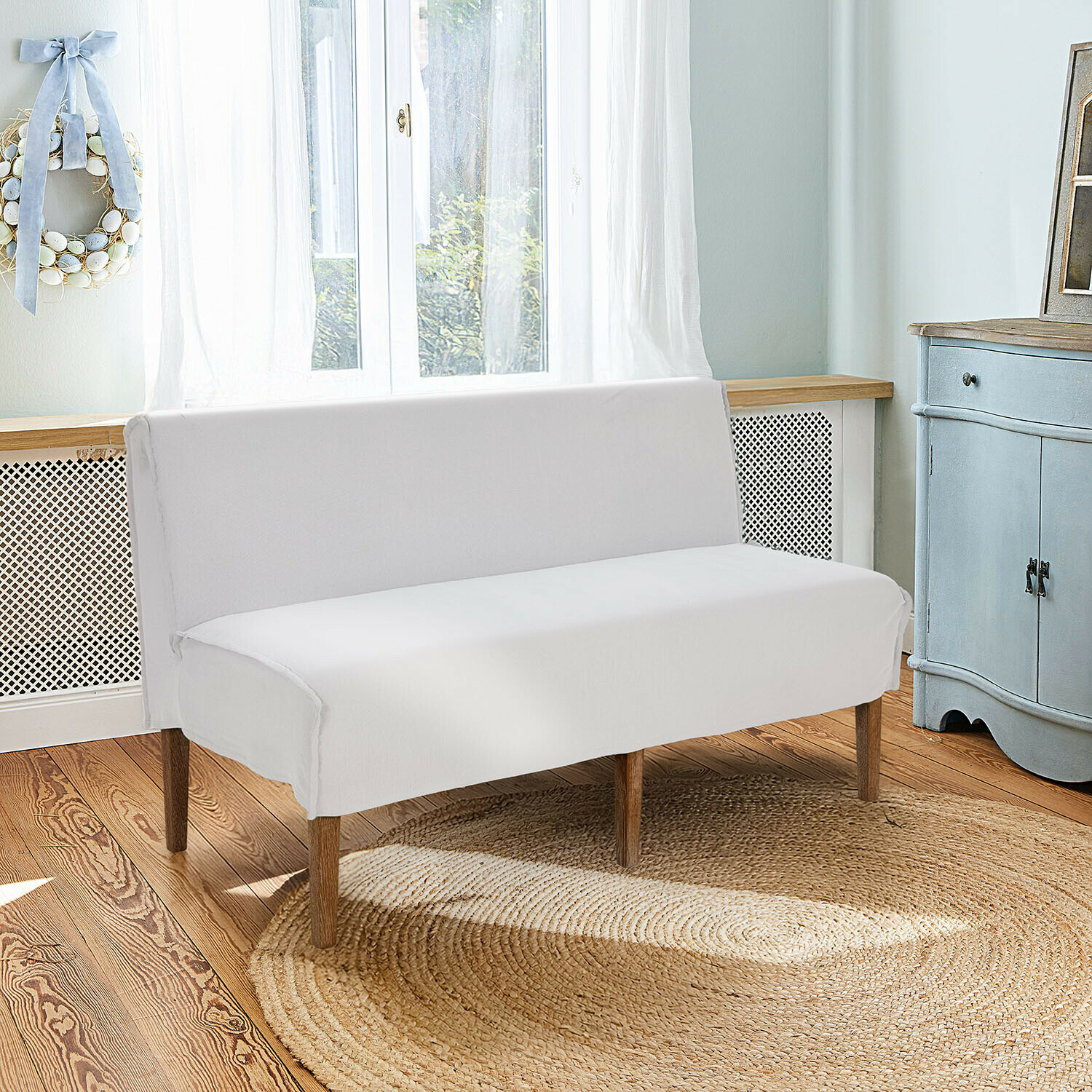 Keukenbank Vinterfjord Witte bank met houten poten op ronde jute vloerkleed in lichte, gezellige kamer