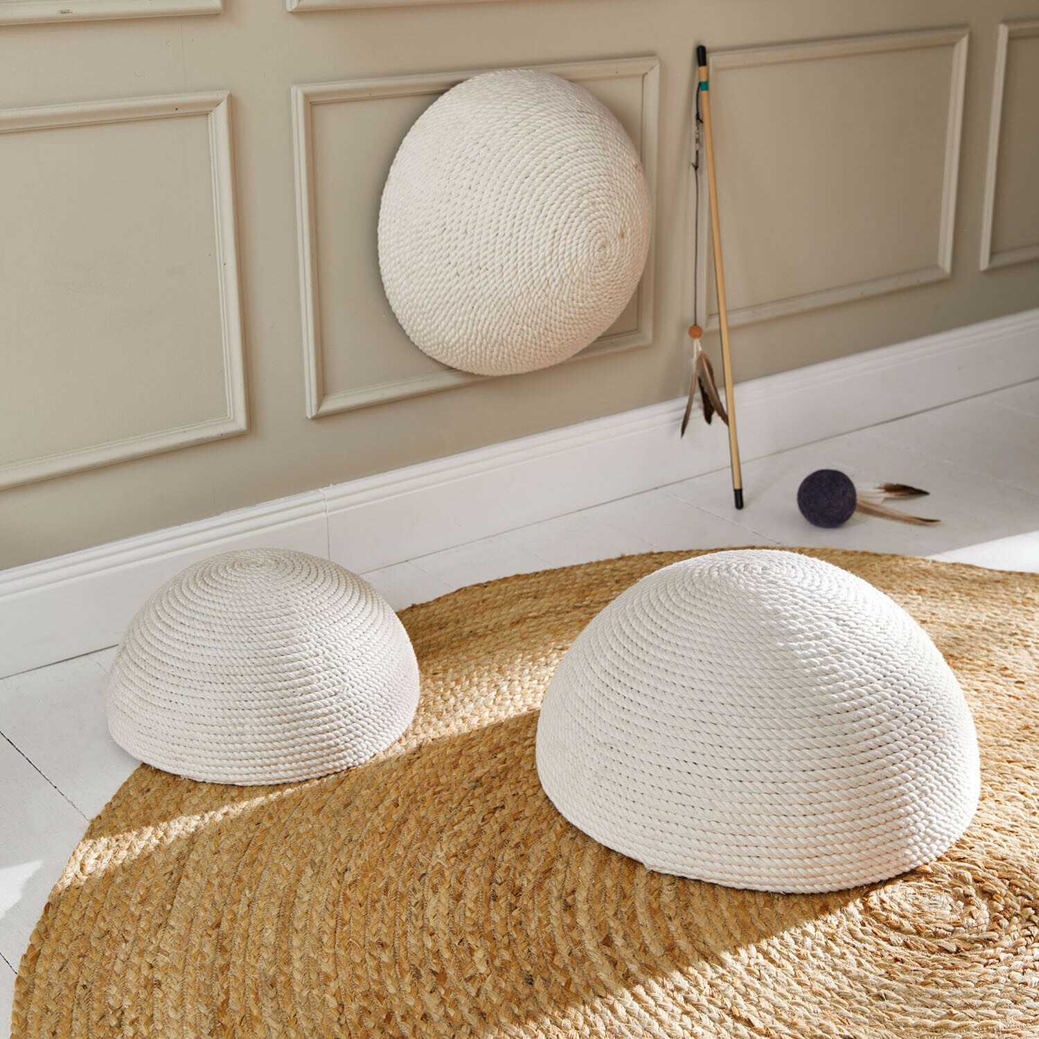 Krabornament set van 3 Hallira Drie witte halve bollen van gevlochten touw op een ronde jute vloerkleed in een lichte kamer