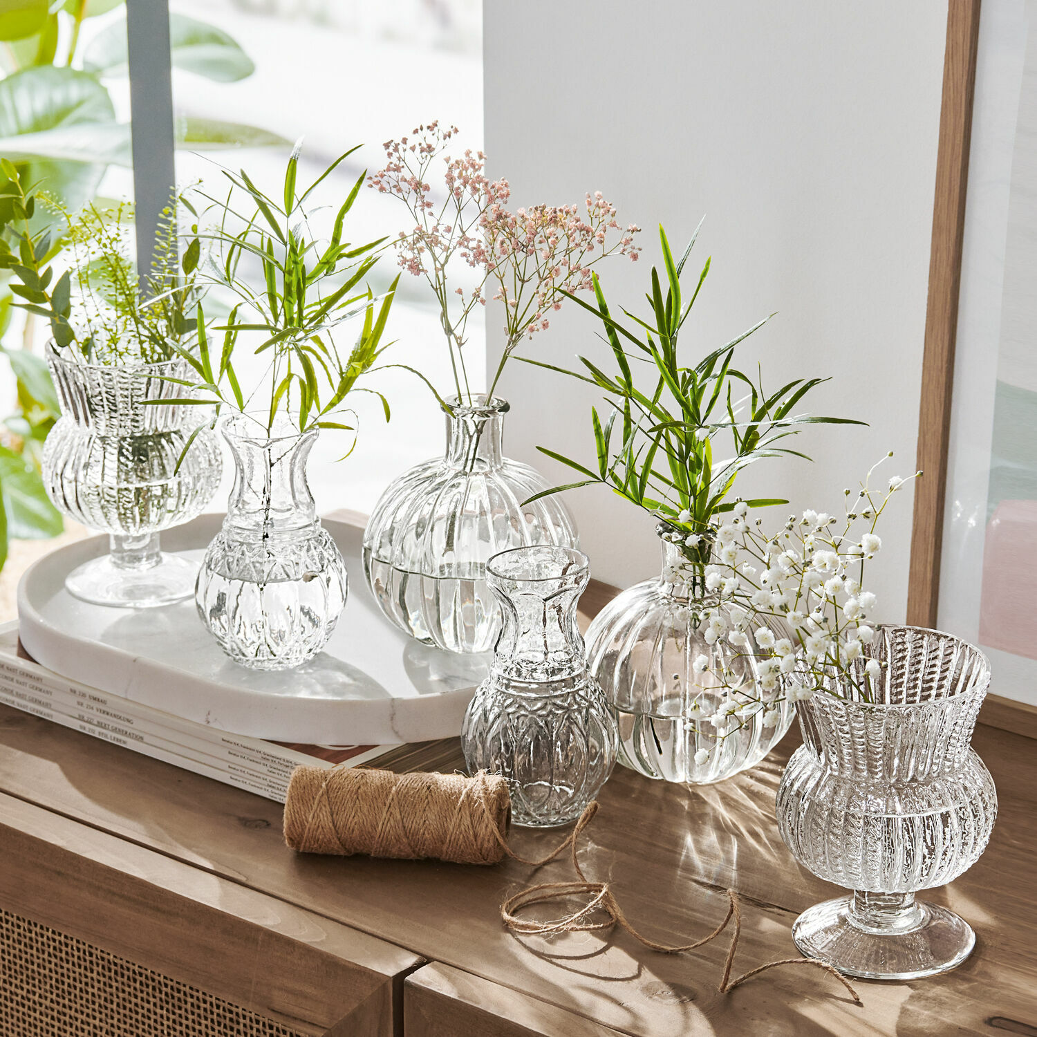 Vaas set van 6 Amber Set transparante glazen vazen met groene en witte bloemen op houten kast