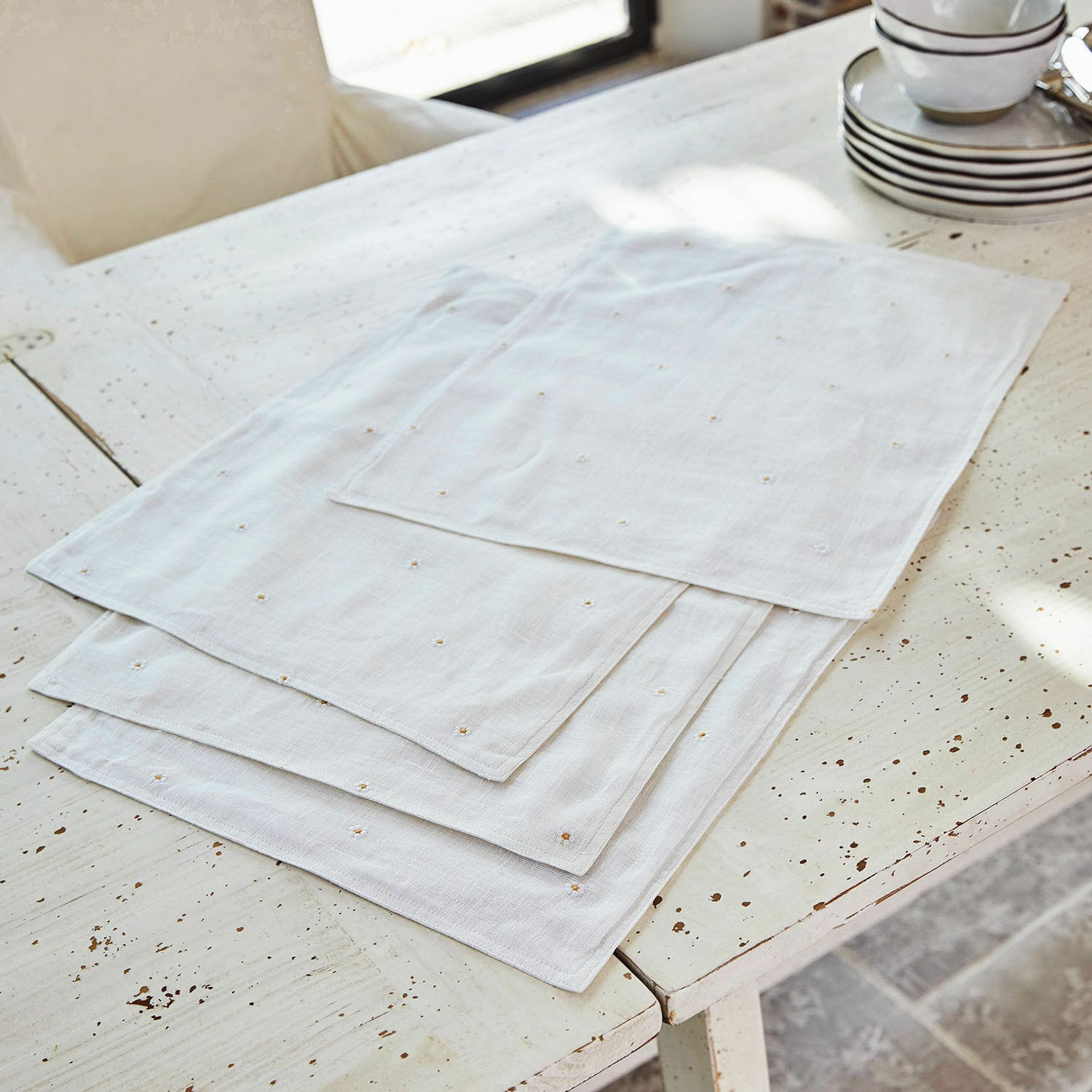 Lot de 4 sets de table Lentilly Serviettes en lin blanc avec broderie délicate sur une table rustique, décoration de table élégante