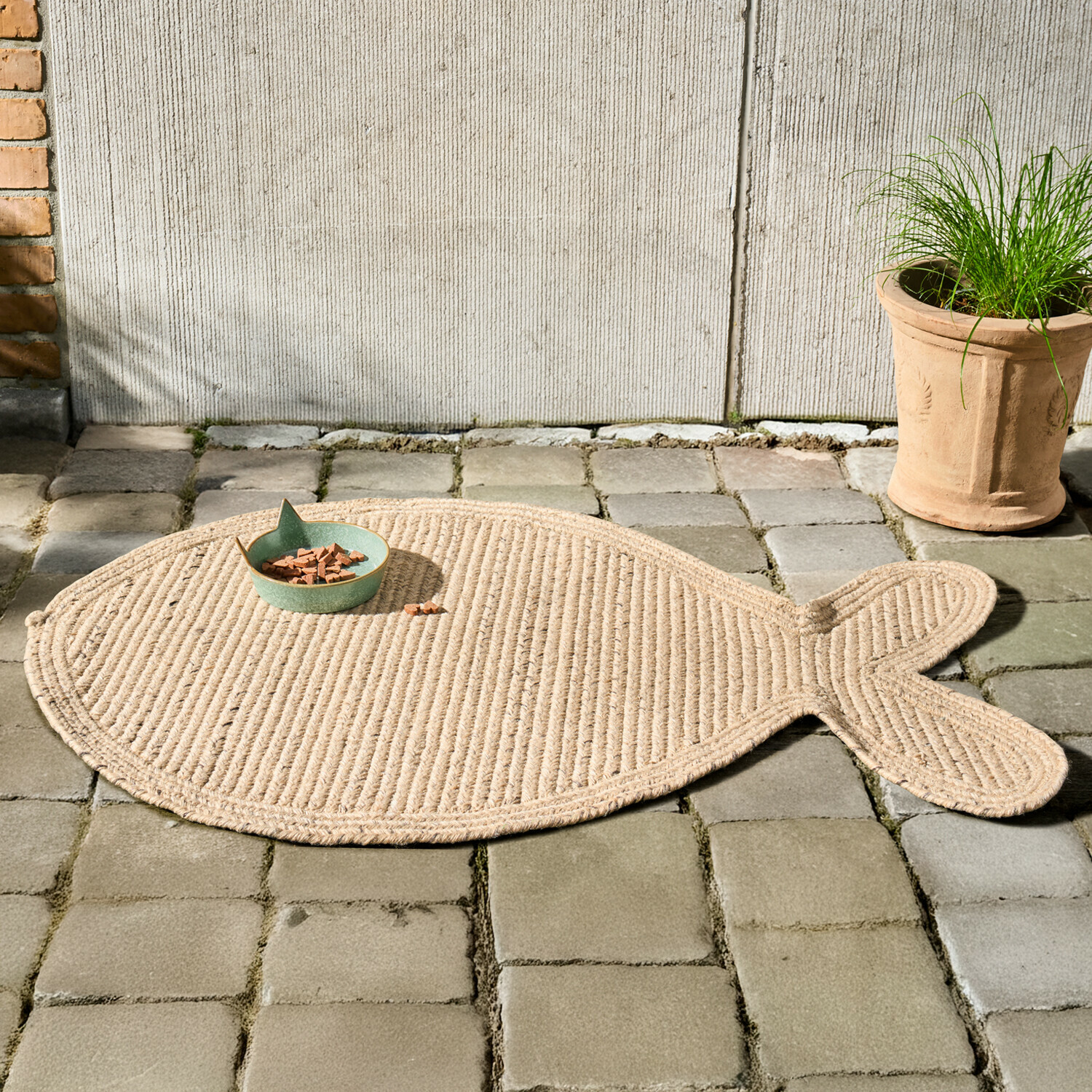 Tapis d’intérieur et d’extérieur Oceravia Tapis en forme de poisson en corde naturelle beige posé sur un sol en pavés gris