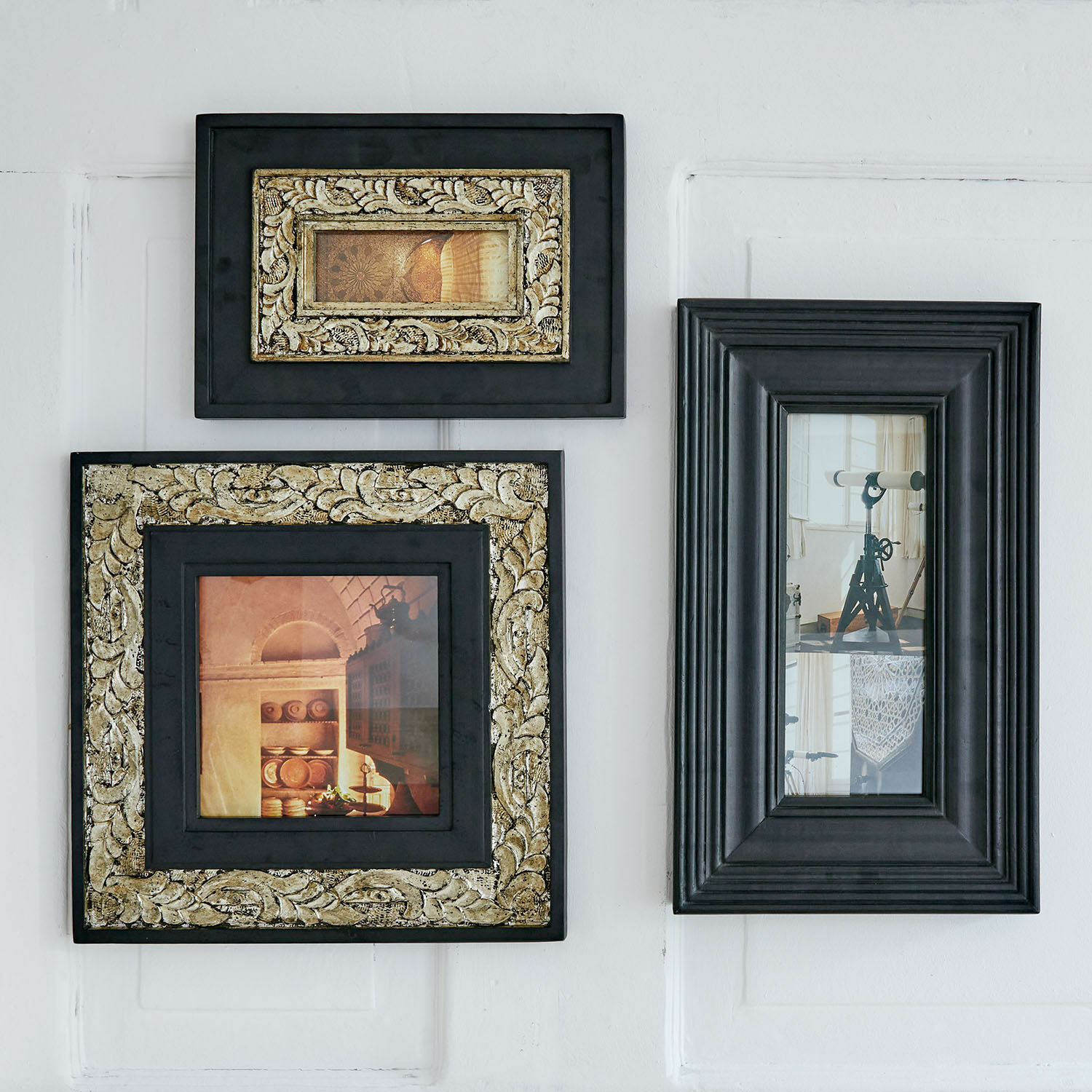 Fotolijst set van 3 Garonnelle Set van drie zwarte houten lijsten met gouden versieringen en decoratieve foto's aan de muur