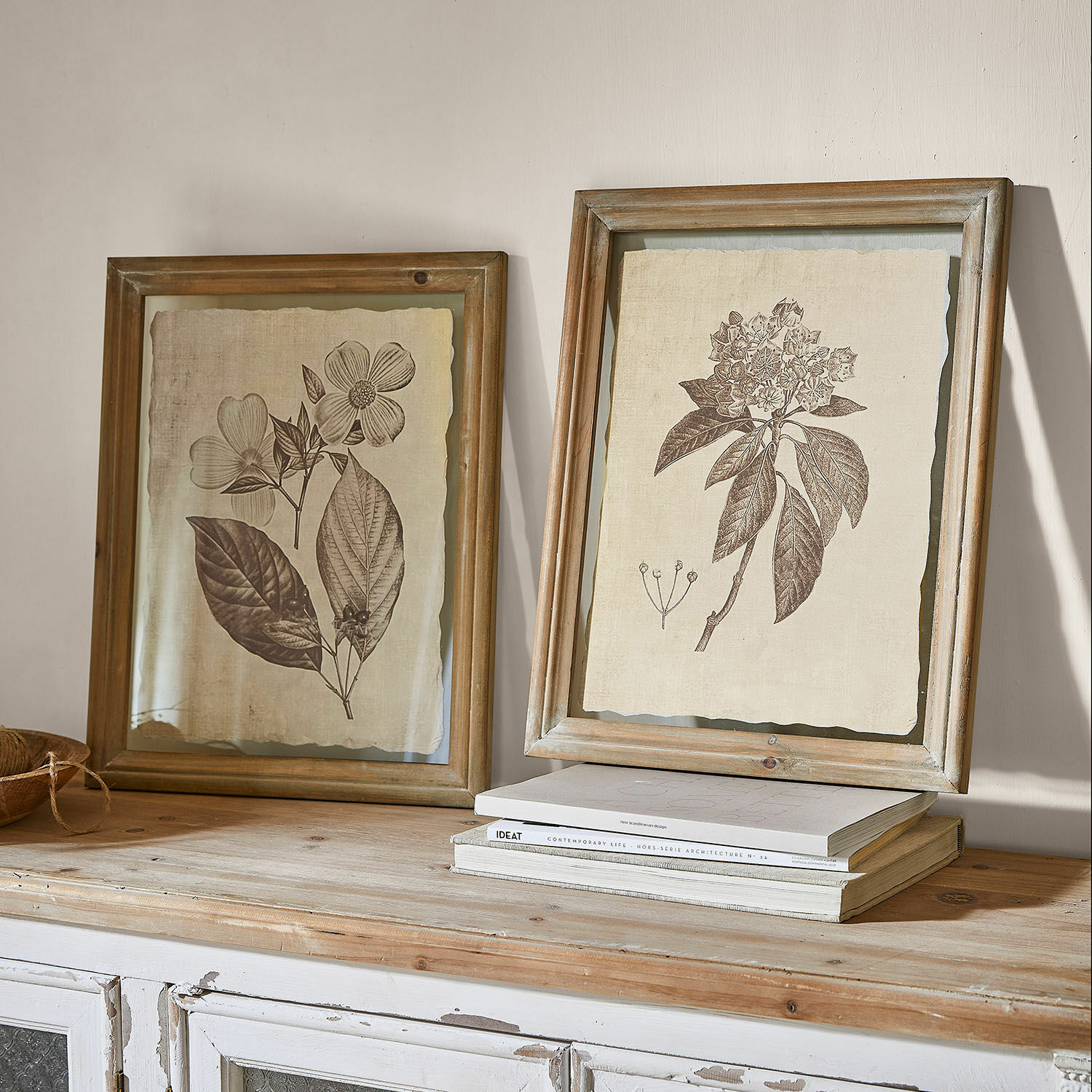 Afbeelding set van 2 Guyra Twee rustieke houten lijsten met botanische bloemtekeningen op beige achtergrond op een houten tafel
