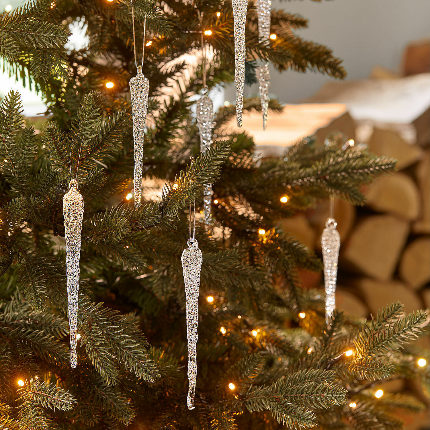 Glazen ijspegel set van 12 Salvique Zilverkleurige ijspegelversieringen aan groene kerstboom met warme kerstverlichting