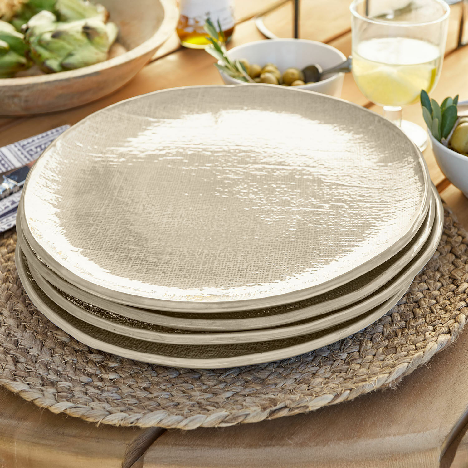 Groot bord set van 4 Luganville Set beige keramische borden met textuur op gevlochten placemat van hout
