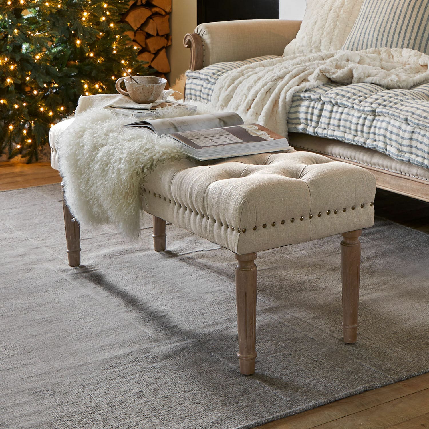 Bankje Brookfield Beige gestoffeerde bank met houten poten op grijs tapijt in gezellige woonkamer met kerstboom