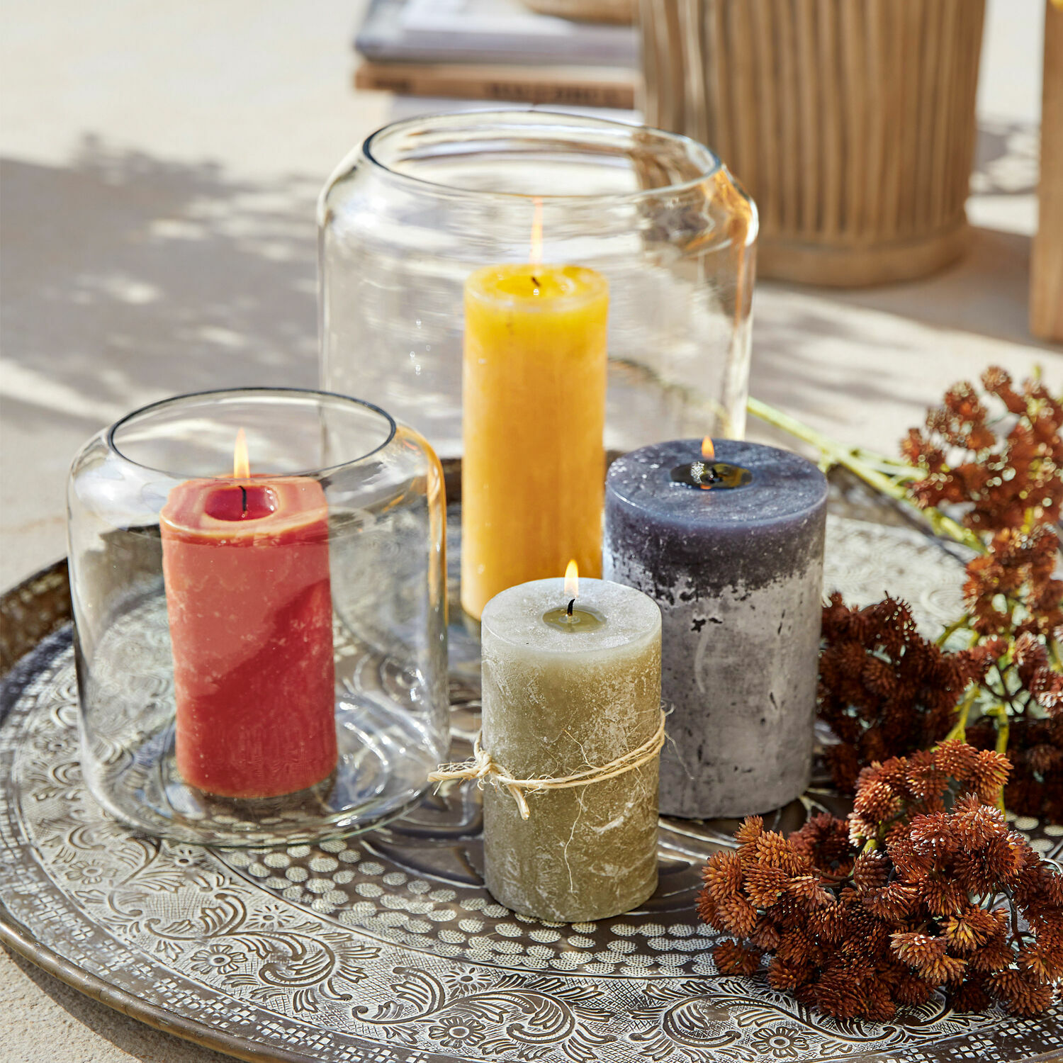 Set van vier gekleurde kaarsen op een decoratieve metalen schaal voor interieurdecoratie