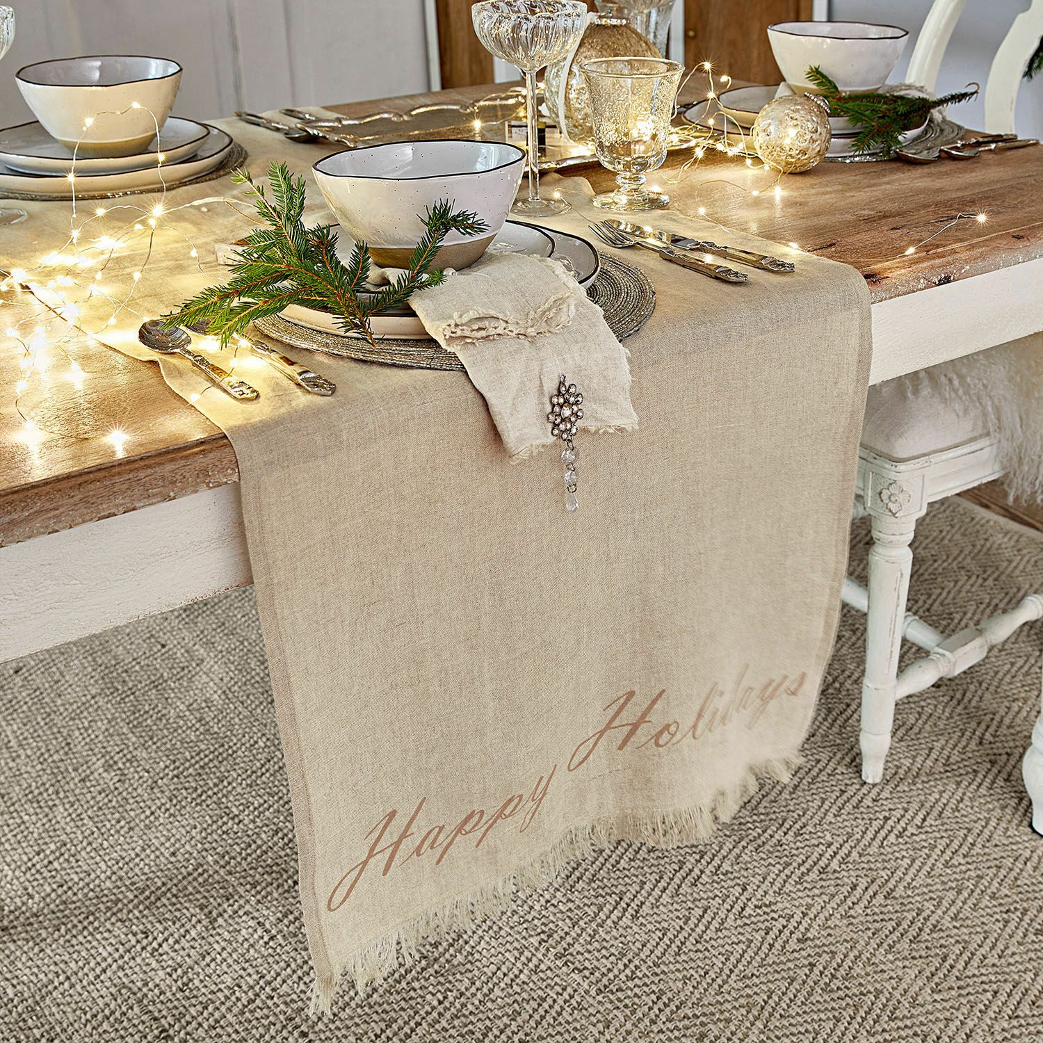 Tafelloper Emilia Beige linnen tafelloper op houten tafel met feestelijke decoratie en servies