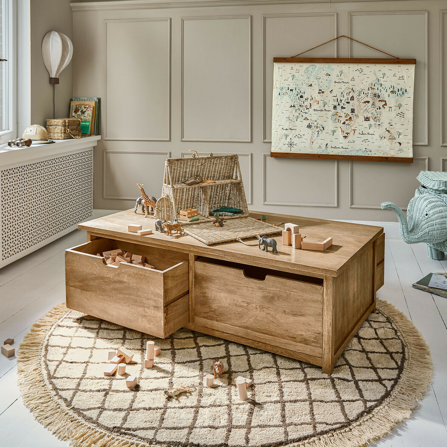 Vloerkleed Puffino Houten speeltafel met lades en houten blokken op ronde vloerkleed in kinderkamer