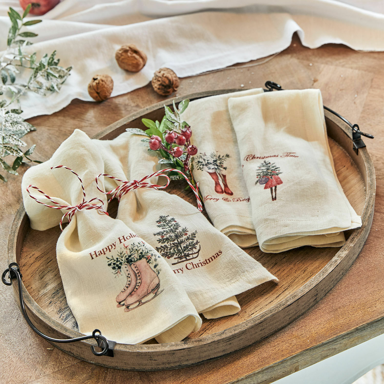 Servet set van 4 Merry & Bright Crème linnen doeken met kerstmotieven en rood koord op rustieke houten schaal
