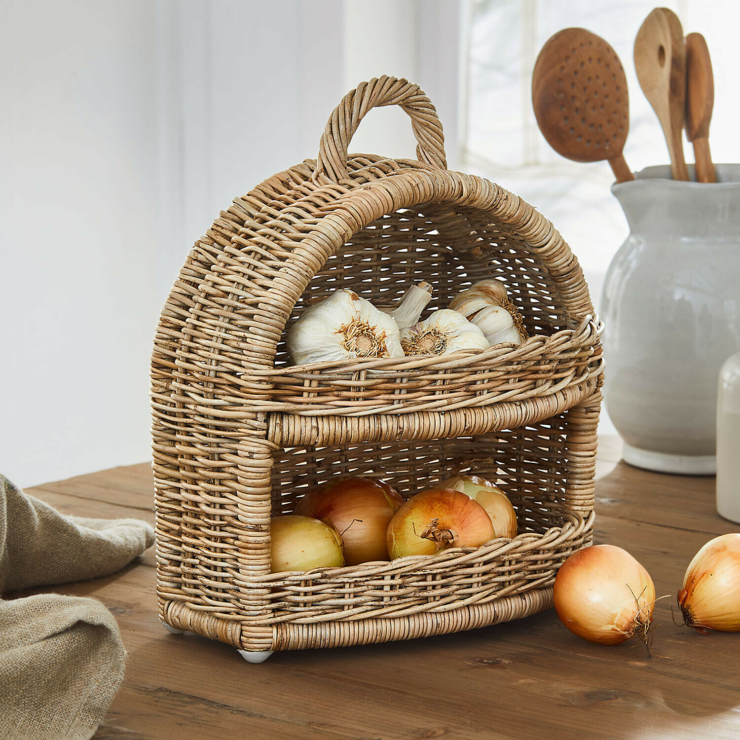 Uienmand Coudrisse Tweedelige mand van natuurlijk riet met knoflook en uien op een rustieke houten tafel