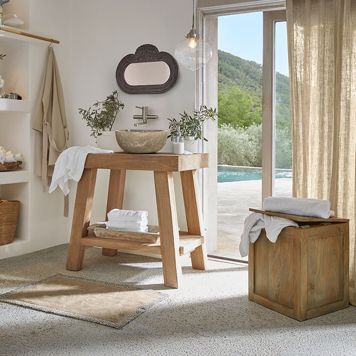 Salle de bain avec meuble en bois et vasque en pierre, ambiance naturelle et lumineuse