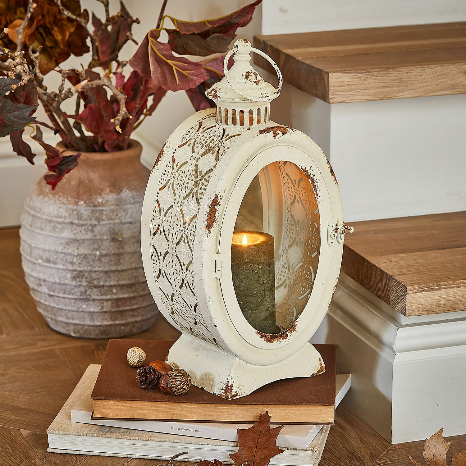 Lanterne Sublimelle Lanterne en métal vintage crème avec bougie allumée et décorations d'automne sur livres