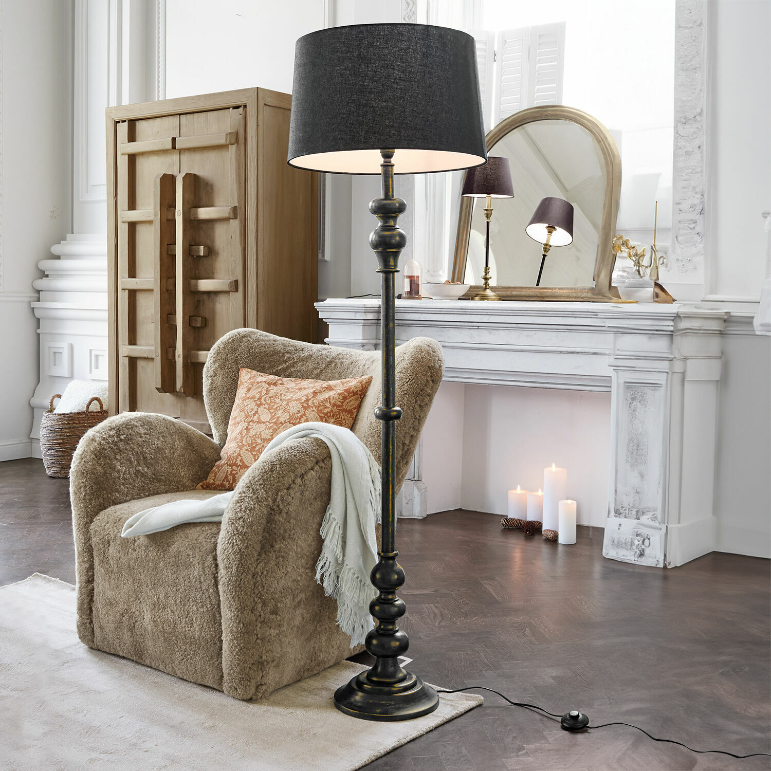 Staande lamp Reville Zwarte vloerlamp met kap in klassieke woonkamer met beige fauteuil en witte open haard