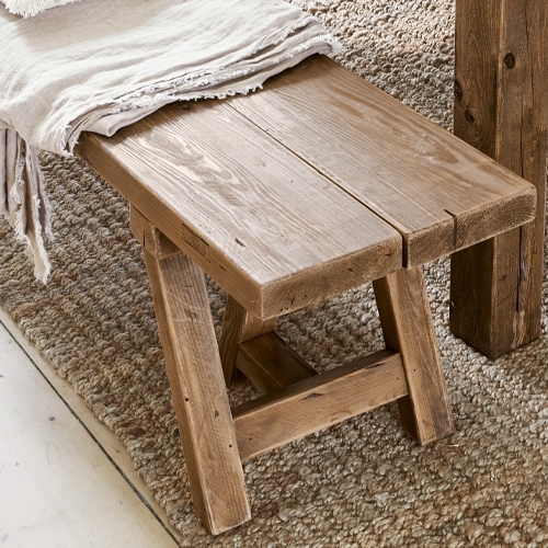 Banc en bois naturel posé sur un tapis, meuble rustique pour salon ou entrée