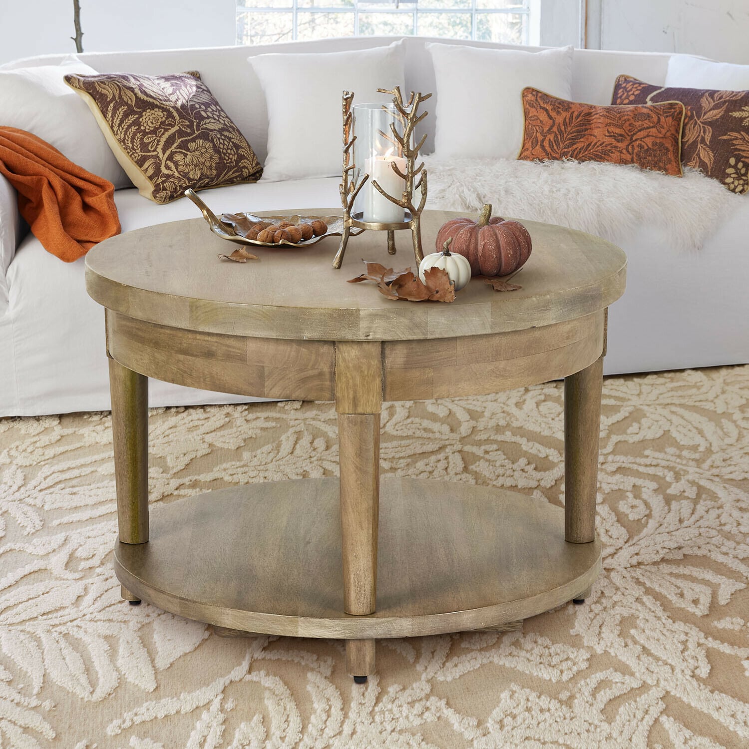 Salontafel Talinar Ronde houten salontafel in natuurlijke kleur met kaars- en pompoendecoratie op beige tapijt