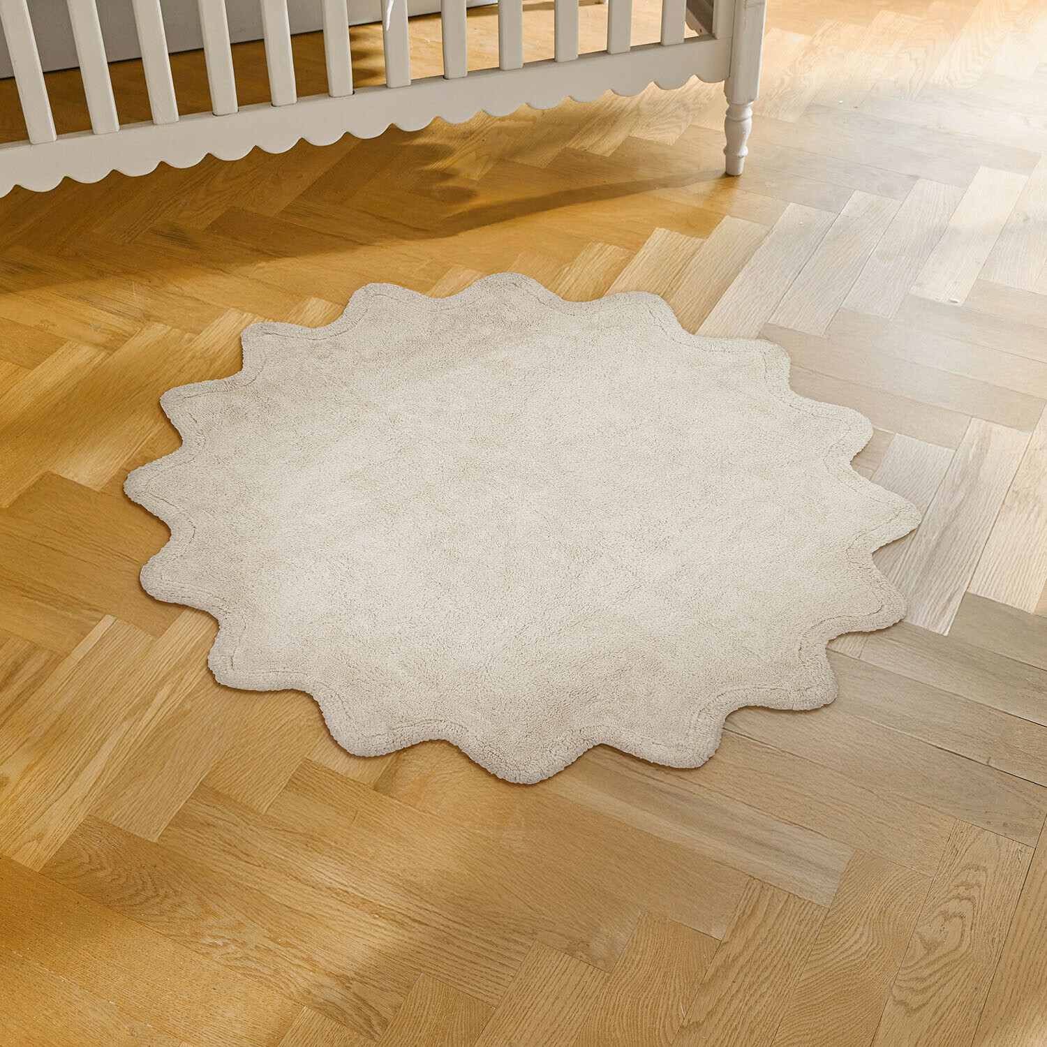 Vloerkleed Wonderfluff Ronde beige vloerkleed van zacht materiaal met golvende rand op lichte houten vloer