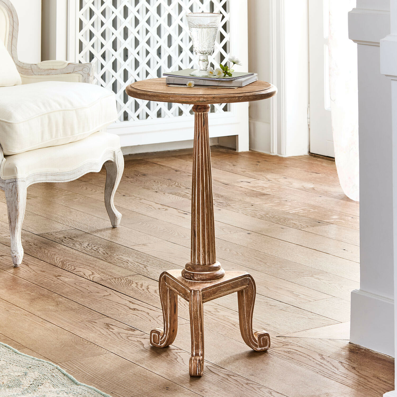 Table d'appoint Taviano Table d'appoint ronde en bois naturel avec pieds décoratifs de style vintage dans un salon lumineux