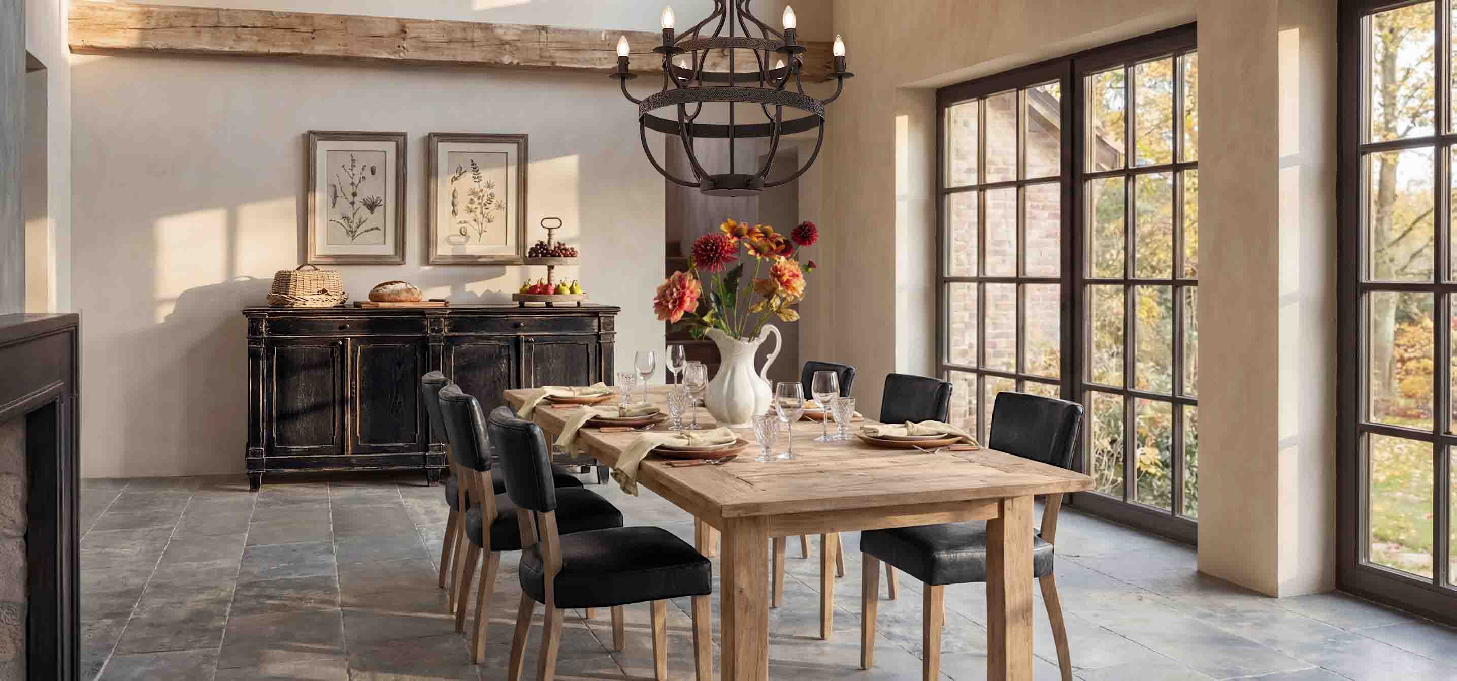 Eetkamer met houten tafel, zwarte stoelen en rustieke dressoir bij grote ramen