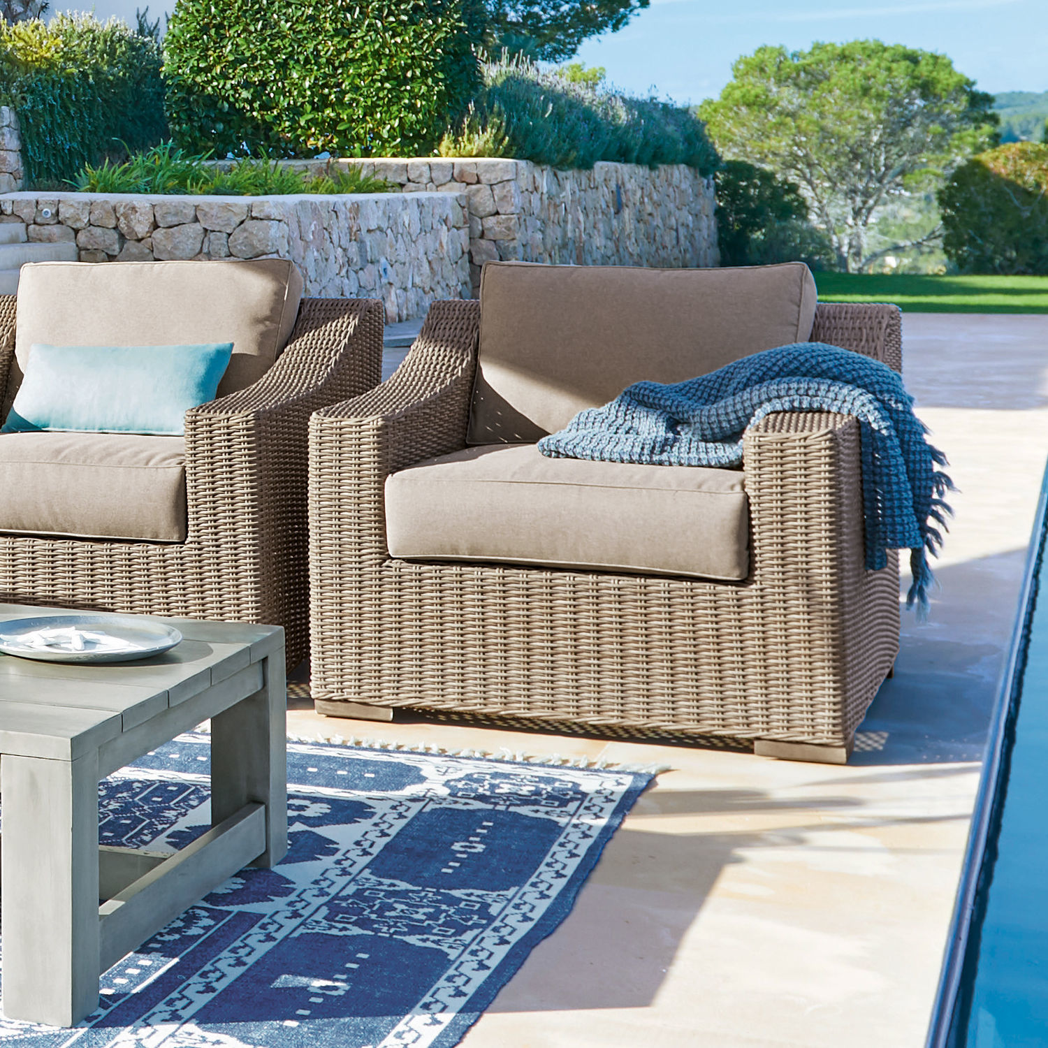 Fauteuil Chestingdale Fauteuil d'extérieur confortable avec coussin beige et structure en rotin marron près de la piscine
