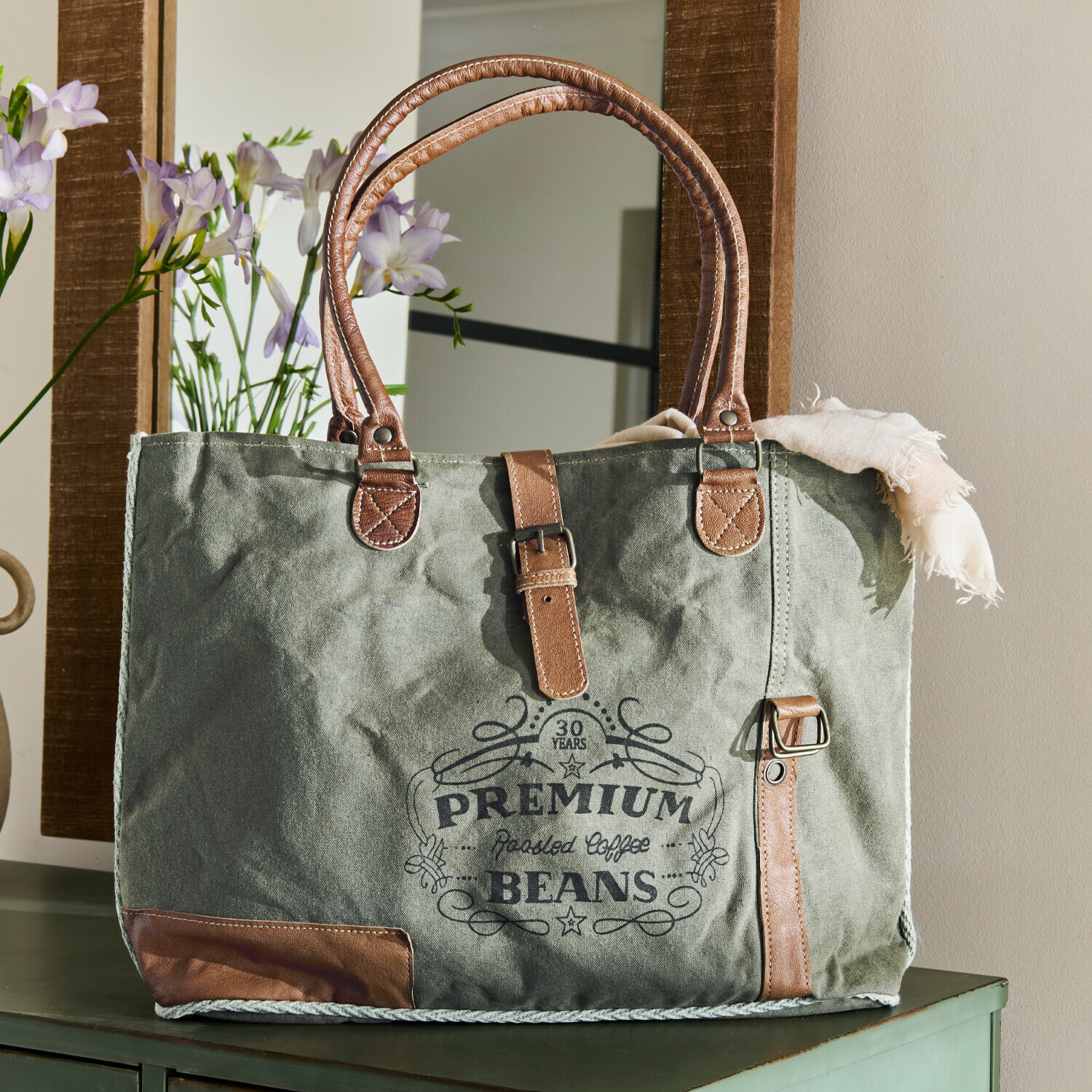 Groene canvas tas met bruine leren handvatten en opdruk premium coffee beans
