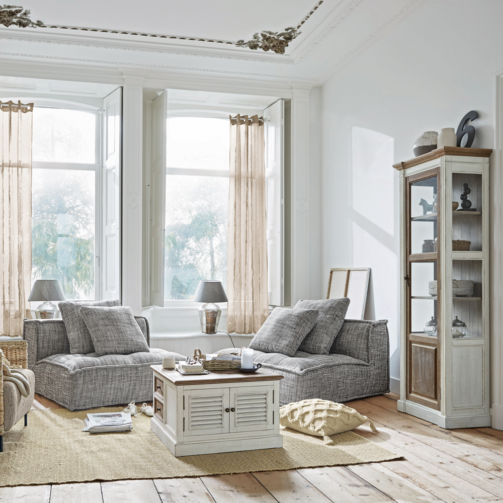 Lichte woonkamer met grijze fauteuils en witte houten kast op jute vloerkleed, Scandinavische stijl
