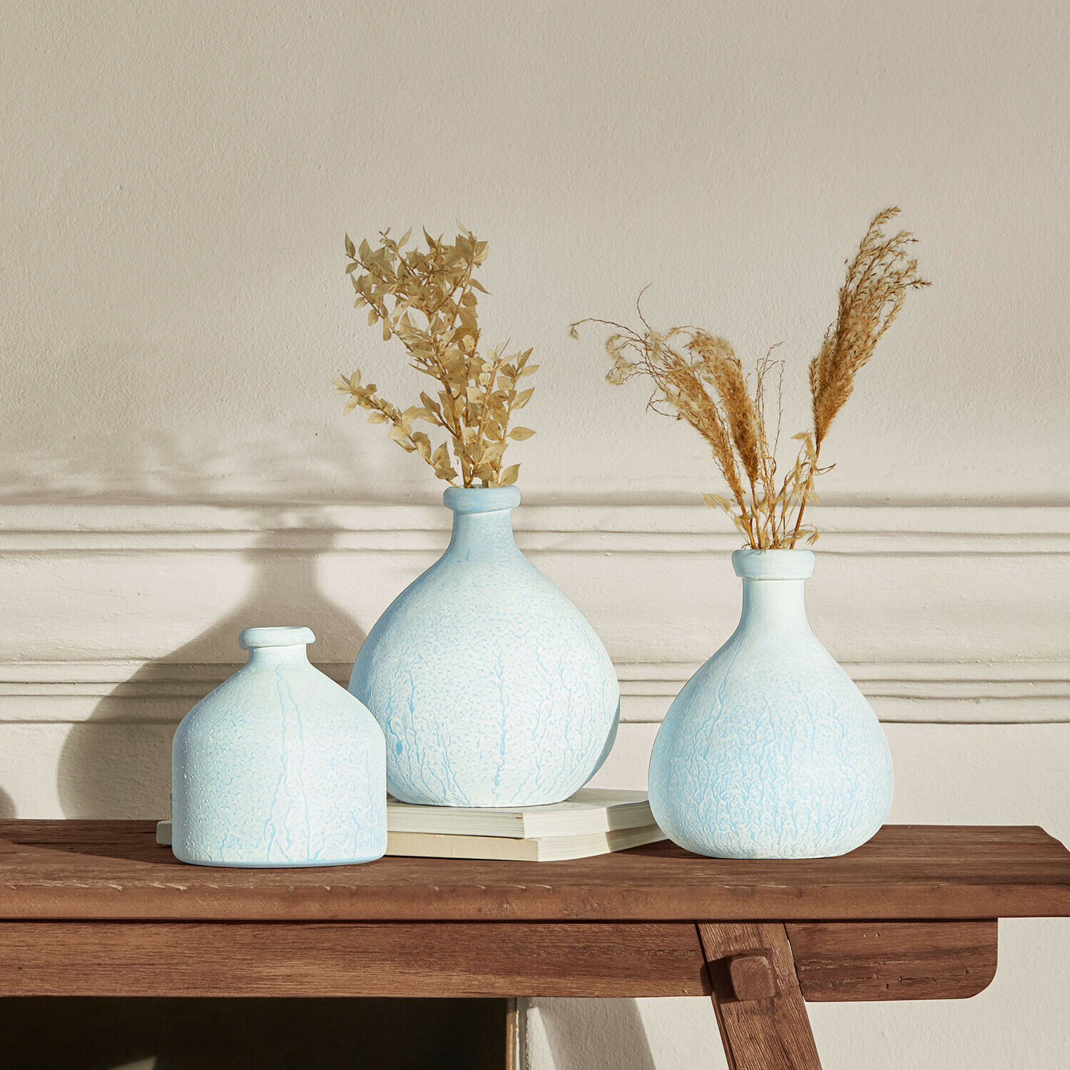 Vaas set van 3 Donara Set van drie lichtblauwe keramische vazen met gedroogde planten op houten tafel voor interieurdecoratie