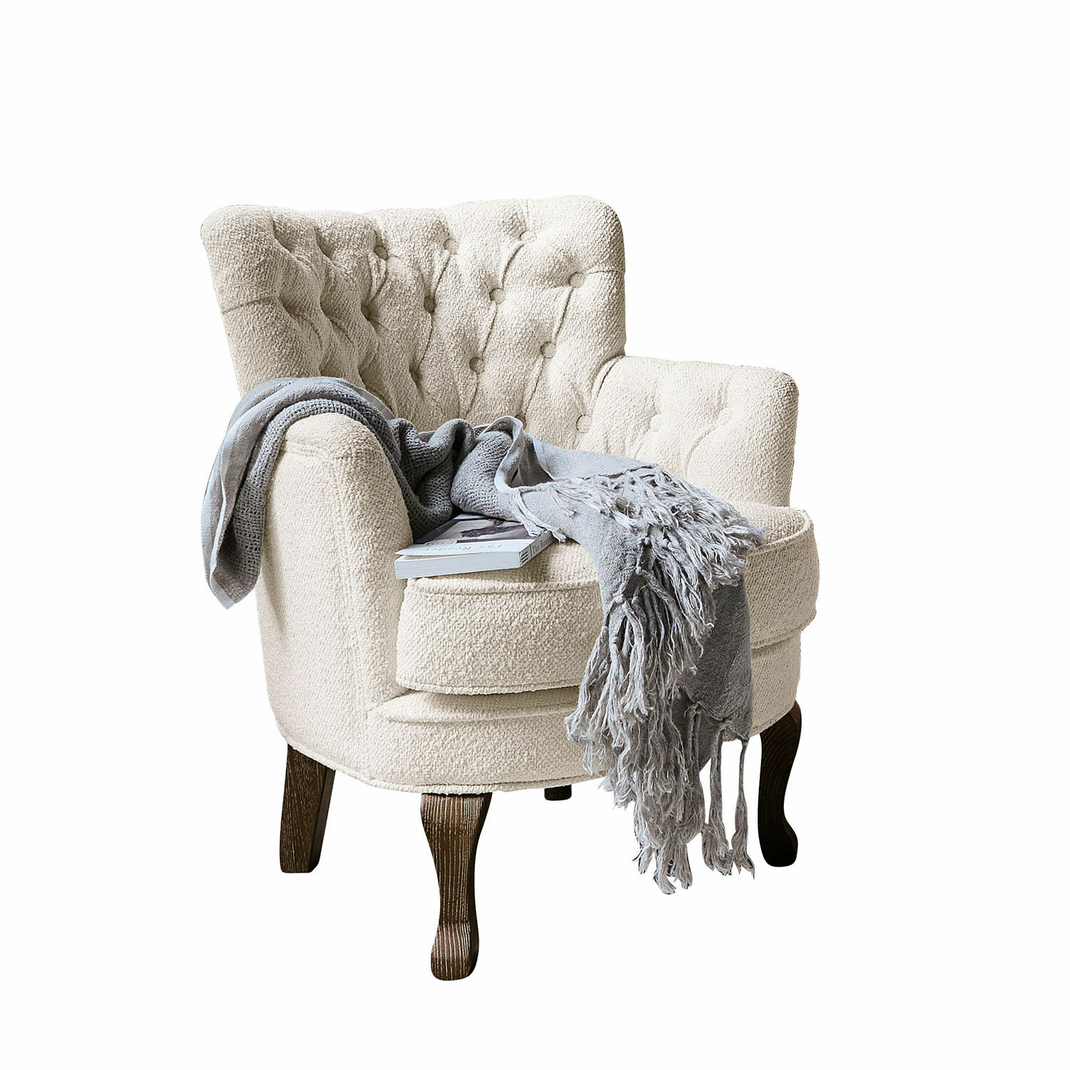 Fauteuil Calgary Beige bouclé fauteuil met donkere houten poten, grijze deken en boek erop