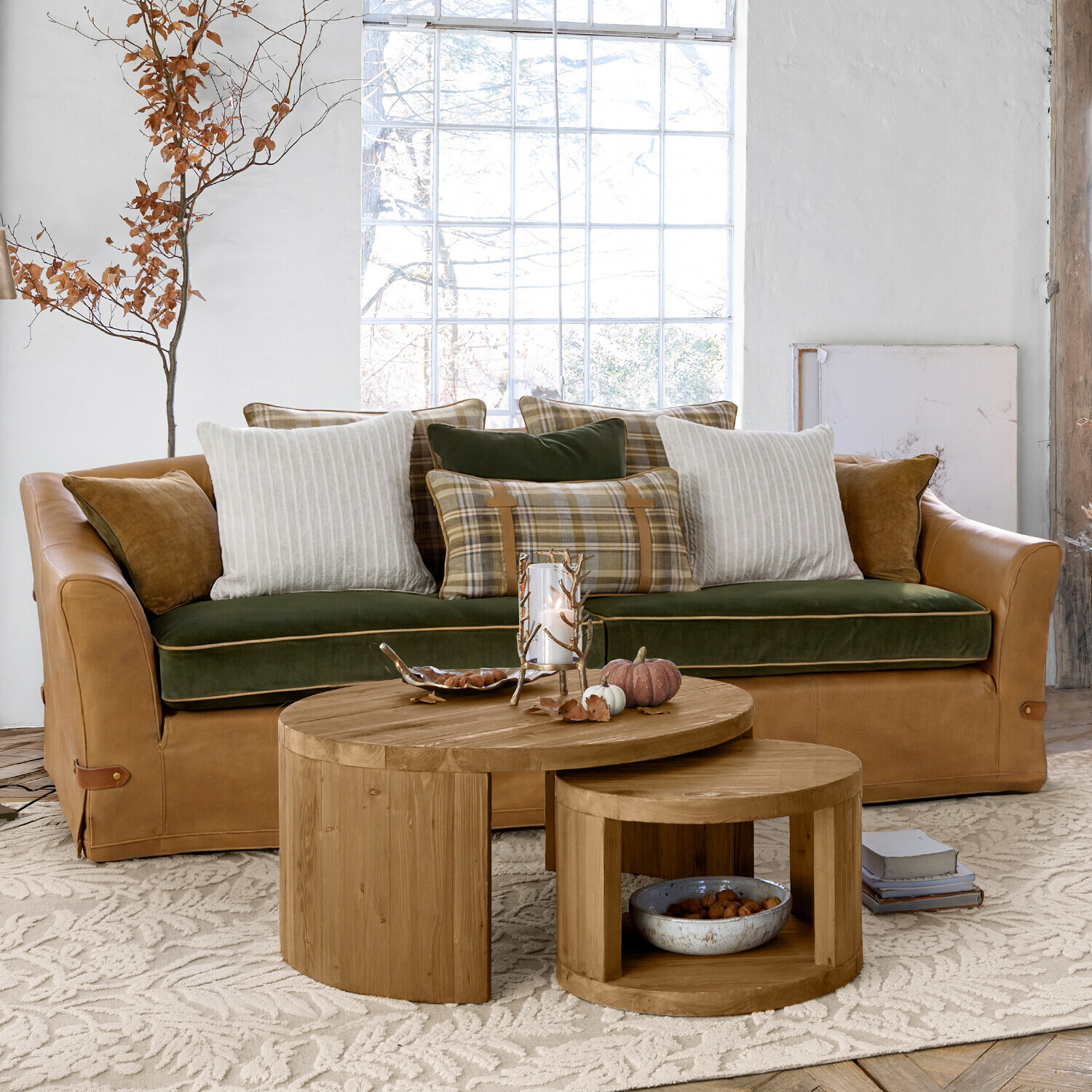 Canapé Halton Canapé en cuir marron avec assise en velours vert et coussins à carreaux et rayures dans un salon lumineux