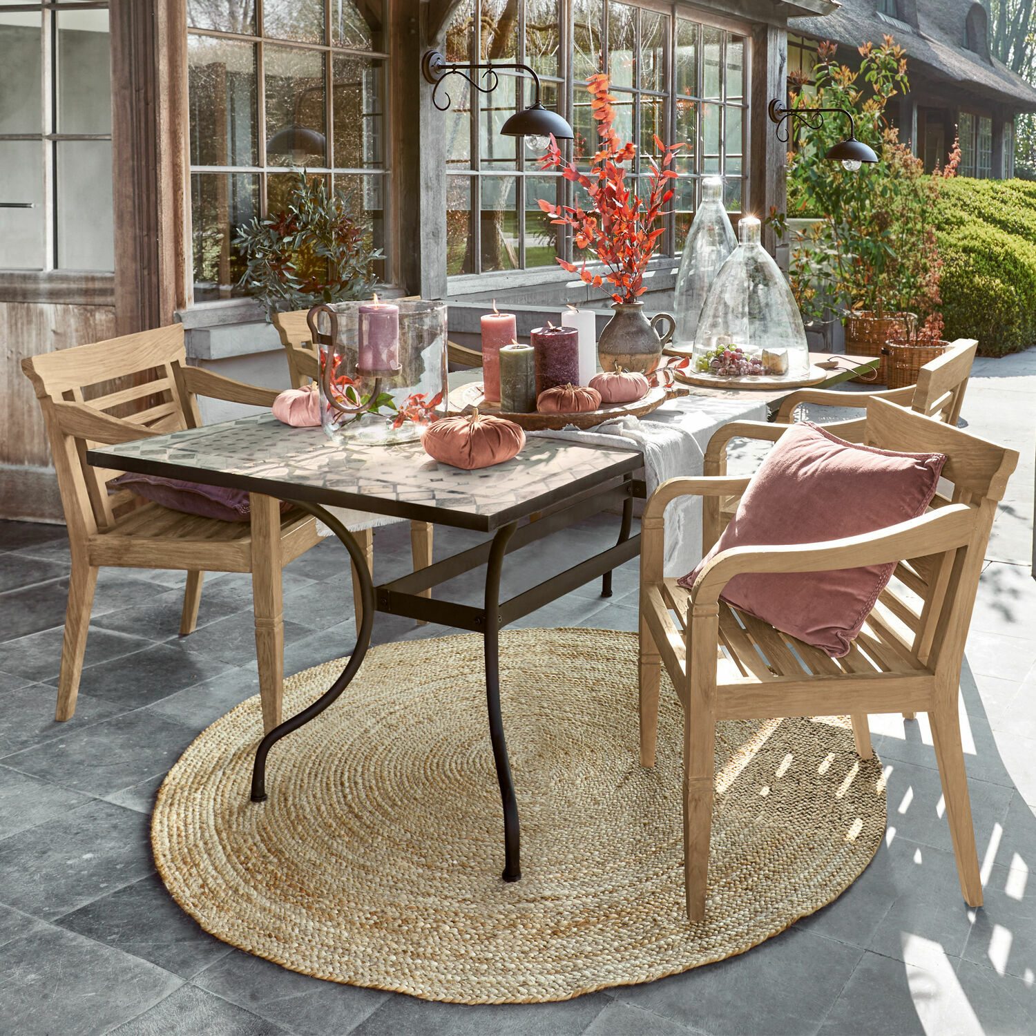 Table Labaroche Table avec pieds en métal et plateau en mosaïque décorée de bougies et coussins roses sur chaises en bois