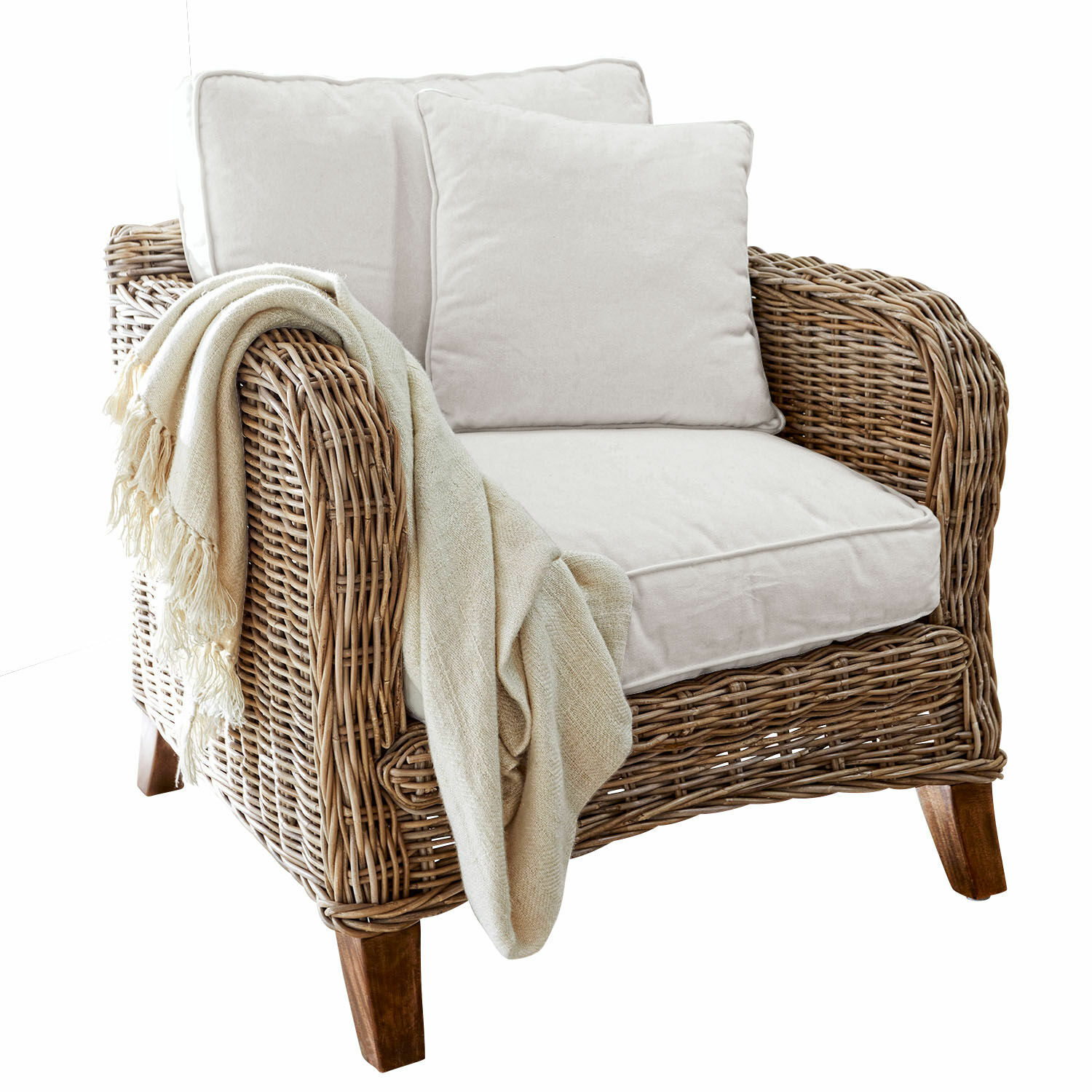 Fauteuil en rotin avec coussins crème et plaid beige, matériau naturel et couleur douce