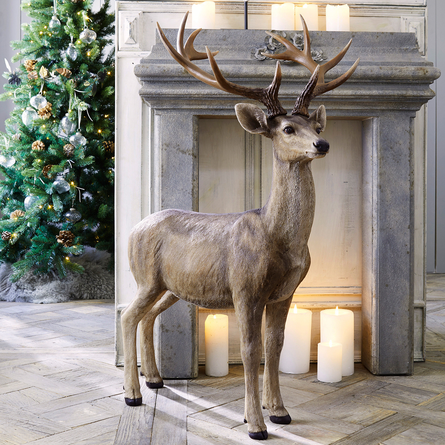 Décoration cerf Storm Sculpture décorative de cerf en résine marron naturel devant une cheminée avec des bougies