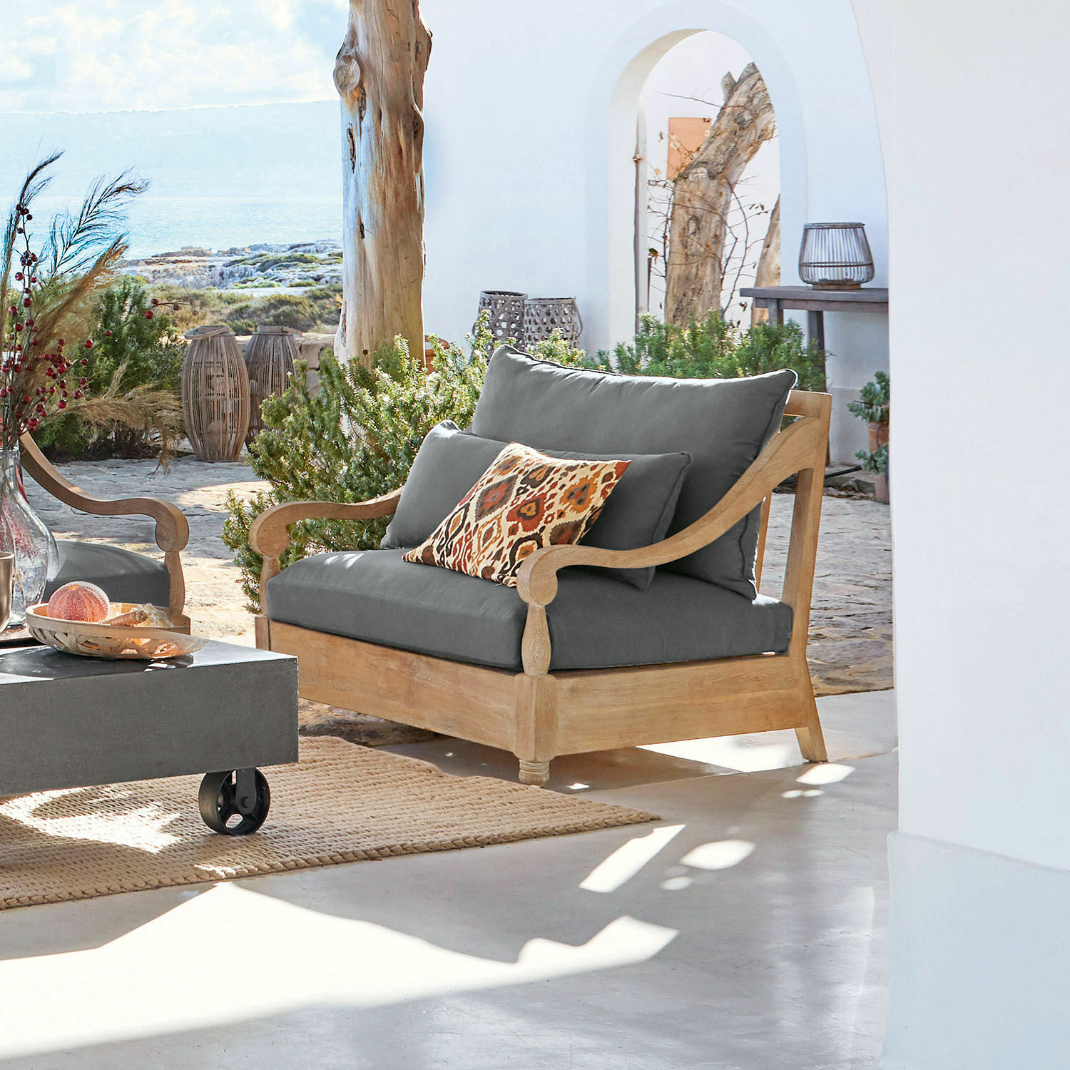 Fauteuil Montcassin Houten tuinbank met grijze kussens en decoratief kussen in warme kleuren